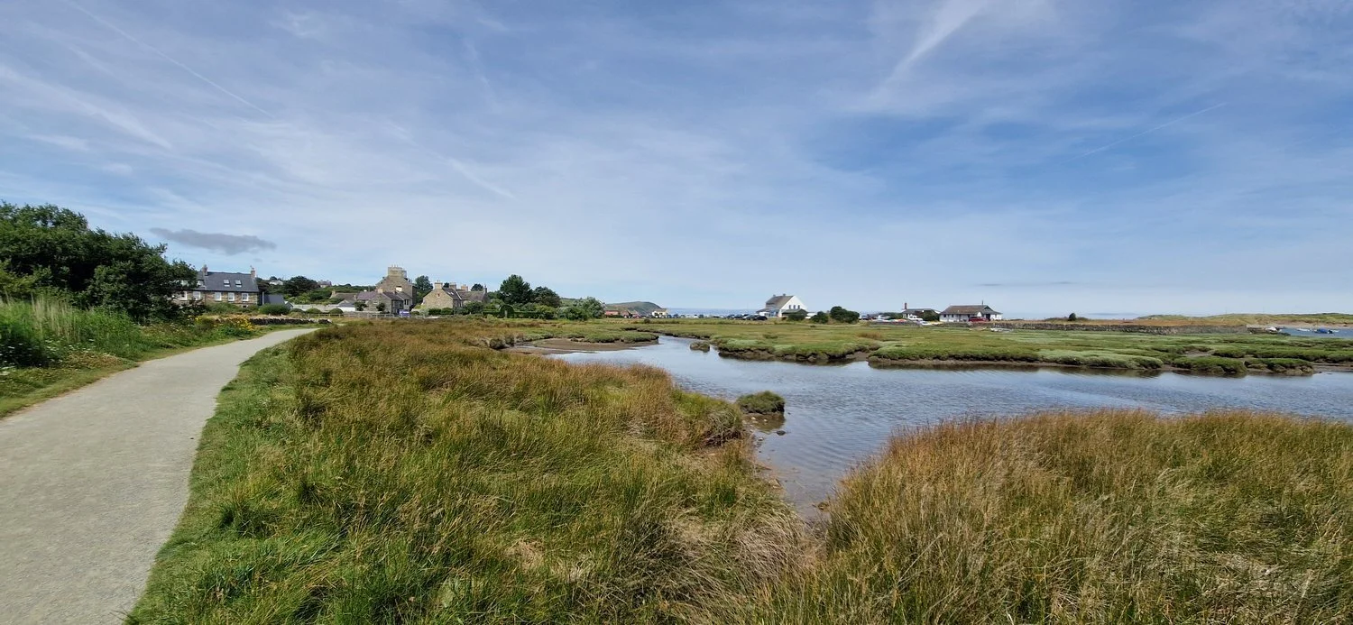 Pathway Along Newport River at high tide with Newport boat club in the distance.