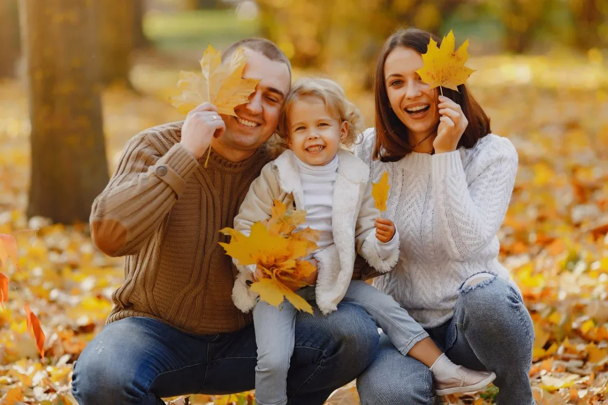 Family playing with leaves in Autumn - October Half Term Holiday - Pembrokeshire