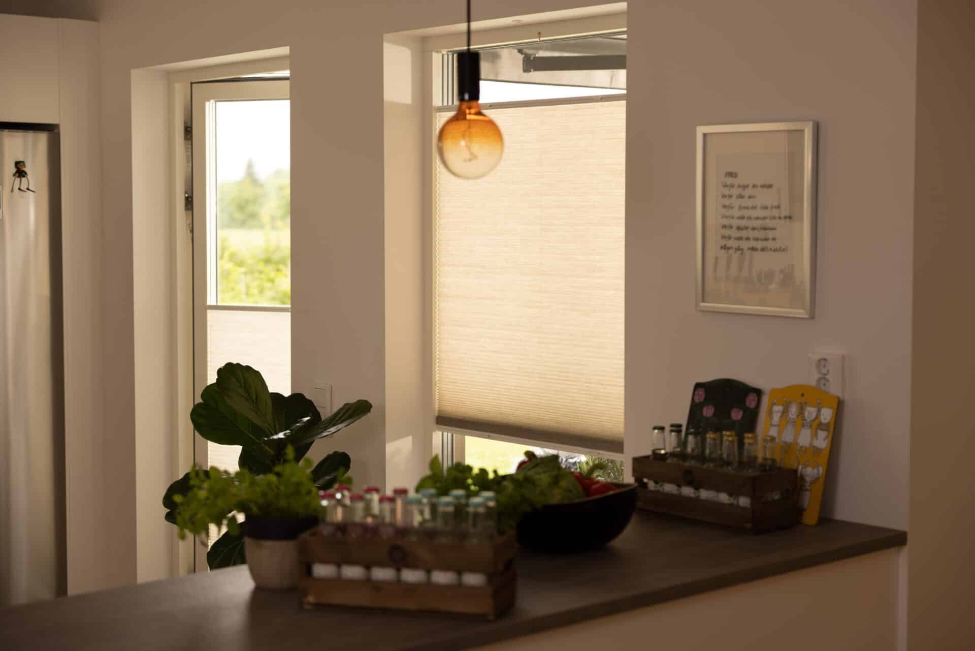 Ljusgenomsläpplig plisségardin i köksfönster i Göteborg – insynsskydd och behagligt dagsljus i ett.