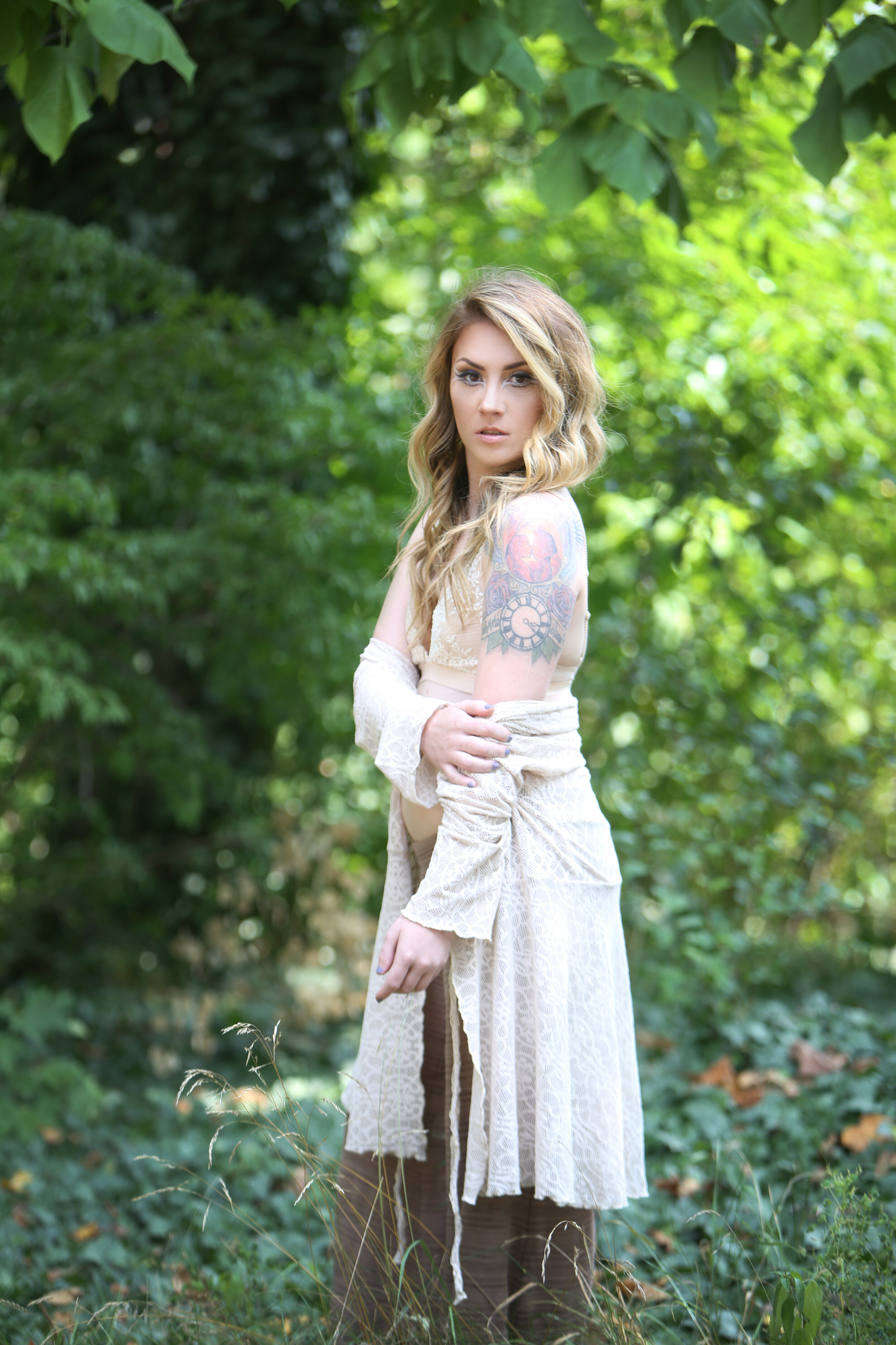 boston boudoir photographer Stephanie Olsen garden goddess woman in lingerie in forest garden ivy doe eye make up tattoo sun flare