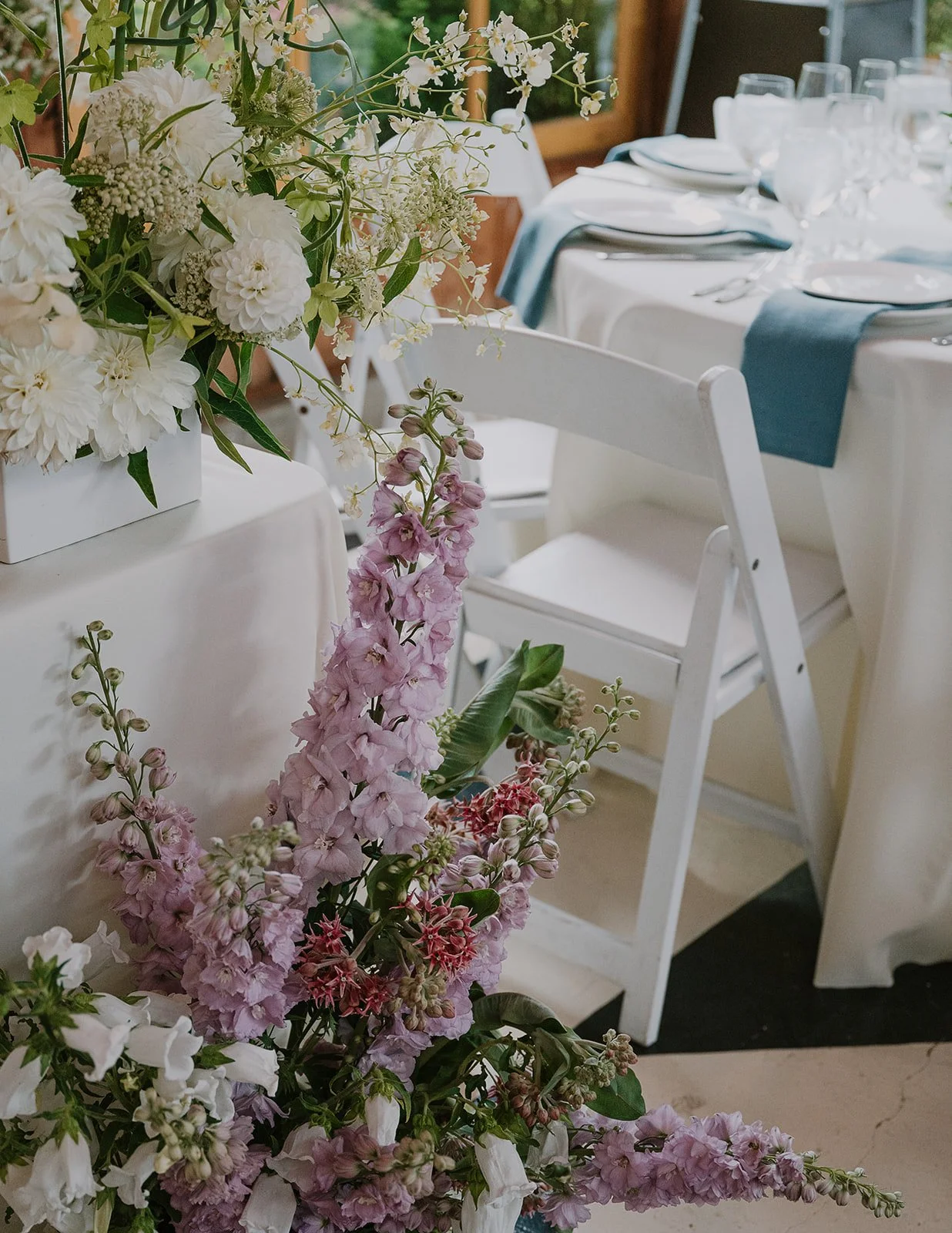 A closeup of the reception flowers surrounding the sweetheart table. Flowers include dahlais, oncidium orchids, delphinium, campanula.