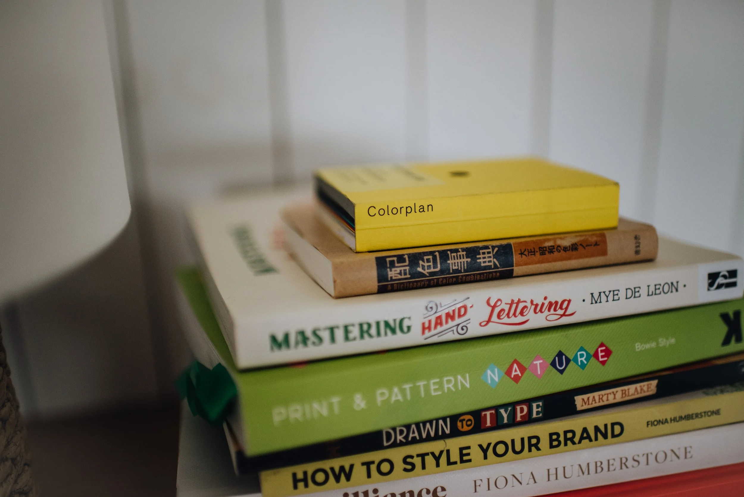 A selection of design related books stacked one on top of the other