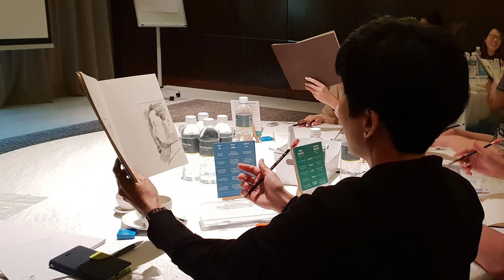 A participant making a quick upside-down drawing during a Growth Mindset Journey, a Drawing Right corporate workshop