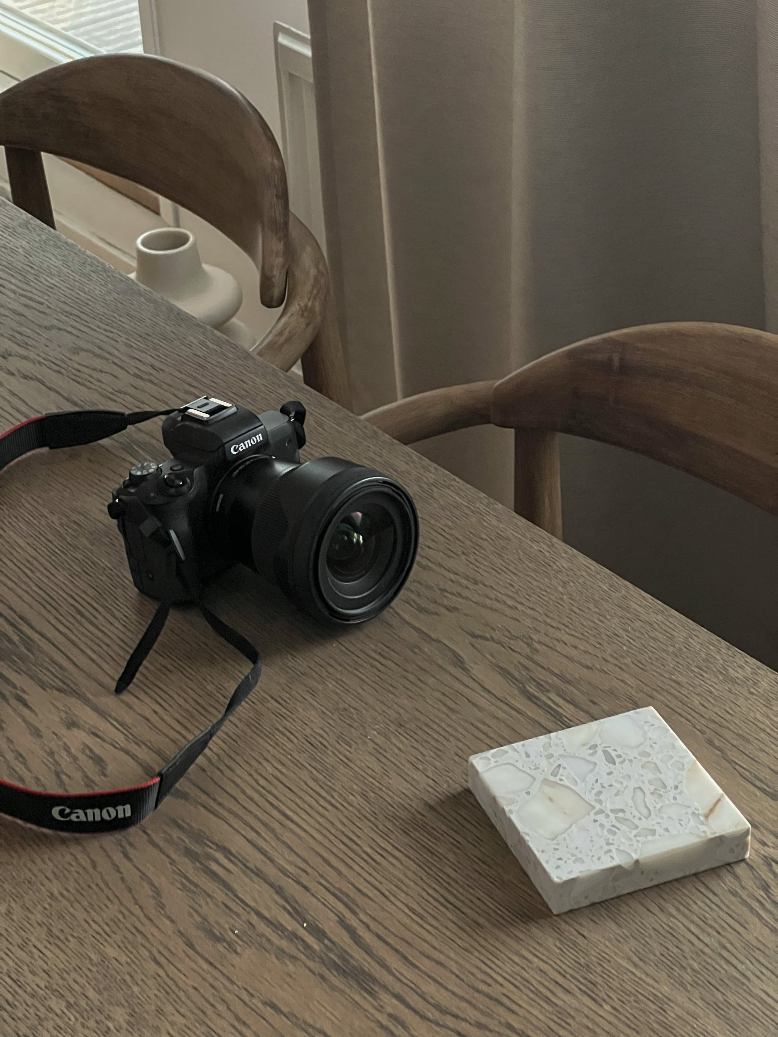 Canonin digikamero ja valkoinen marmorilevy pöydällä.