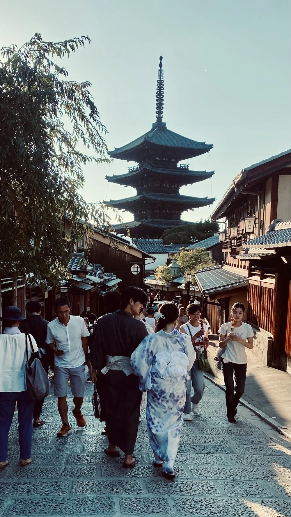   Una parejilla ataviados con trajes tradicionales , paseando por Kioto con el templo Hōkan-ji al fondo. Más japonés que yo que sé. 