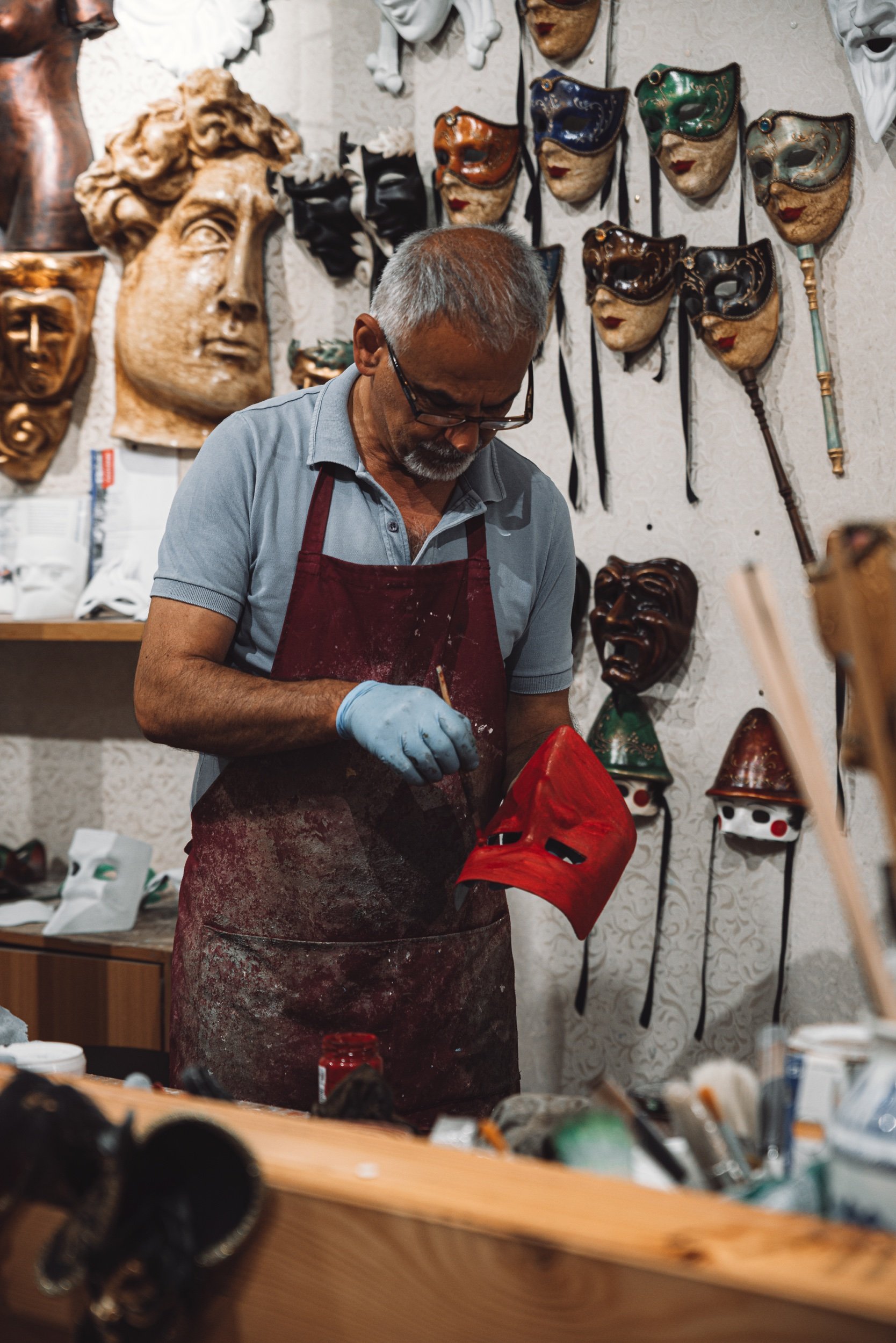 Künstler bemalt Masken in Venedig