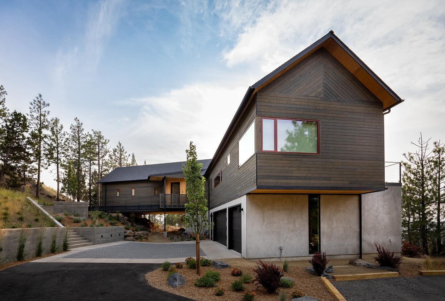 Our recently completed Awbrey Treehouse. The master wing spans over the landscape gently meeting the slope on the uphill side. Guests arrive to at the street above the home and enter into the upper level living areas across a steel entry bridge. 

#i