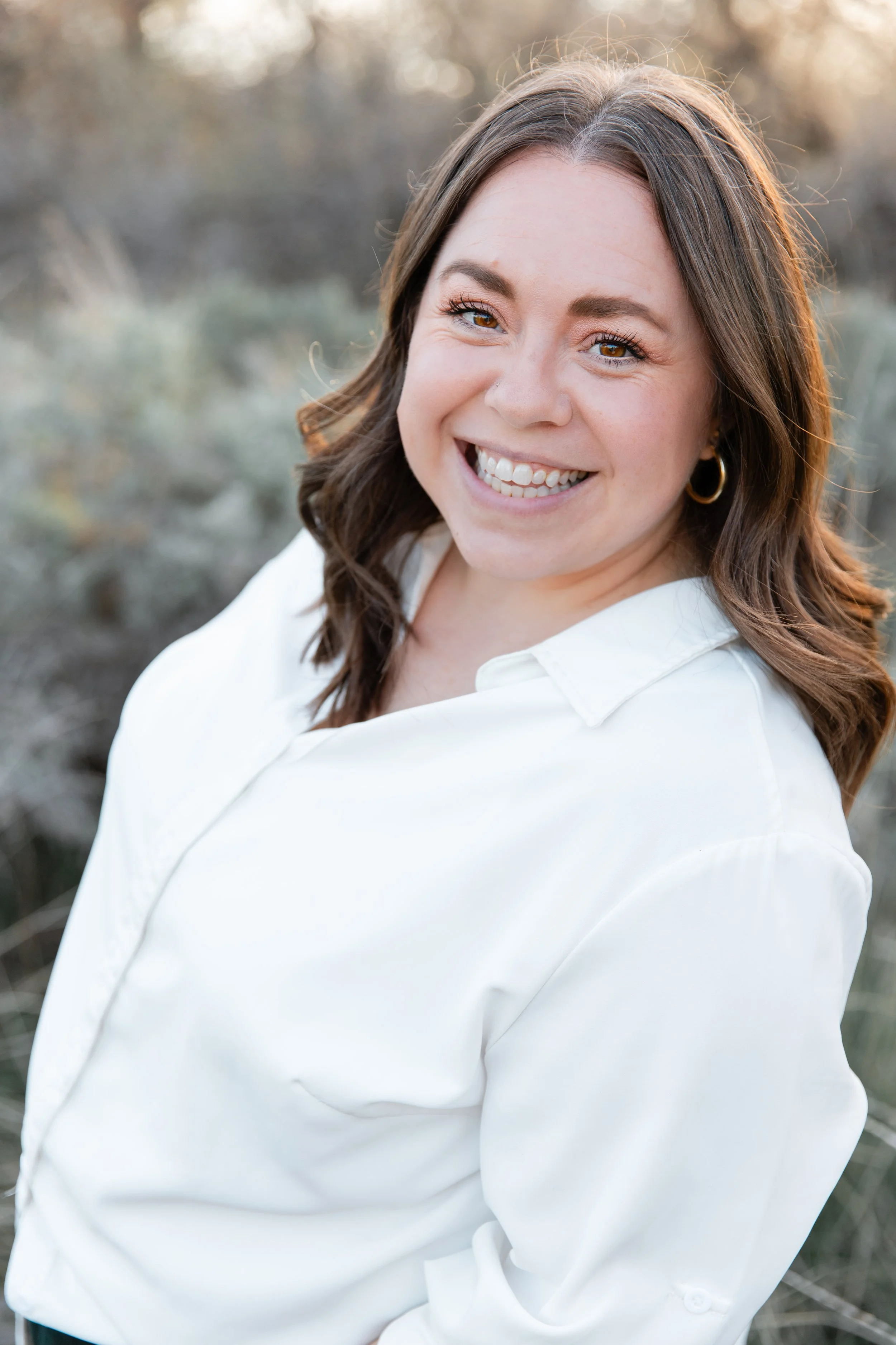 Photo of a female person in a white shirt smiling.