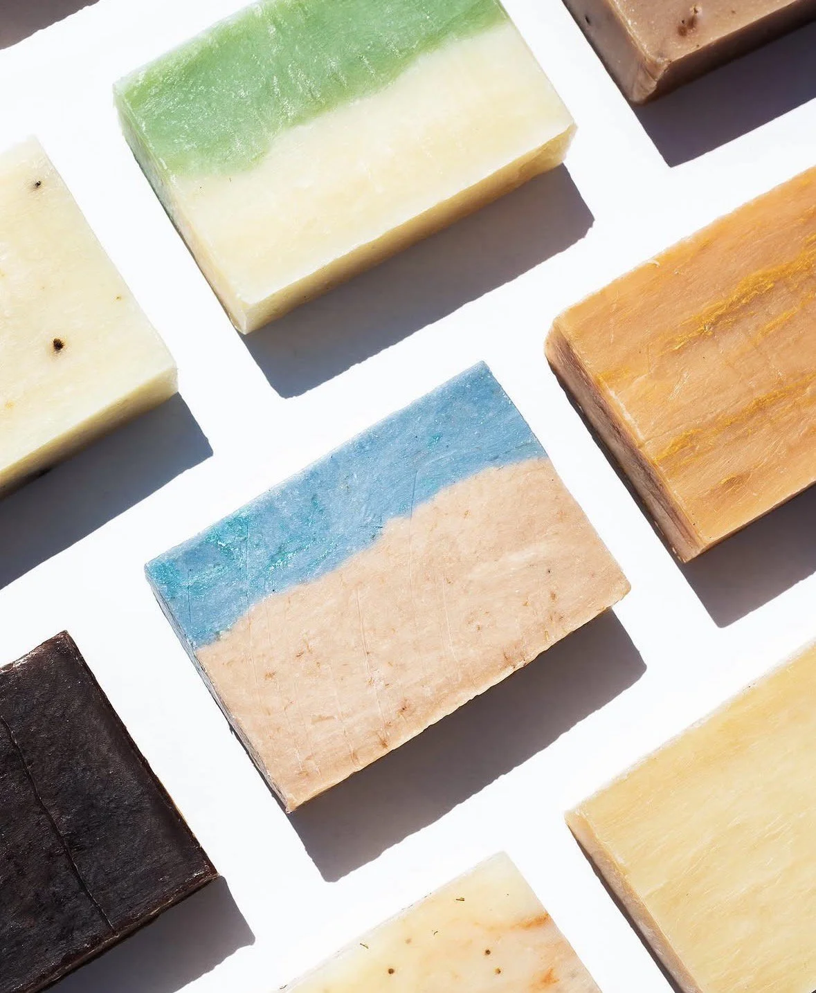 Colorful bars of soap arranged on a white surface, each with different colors and textures.
