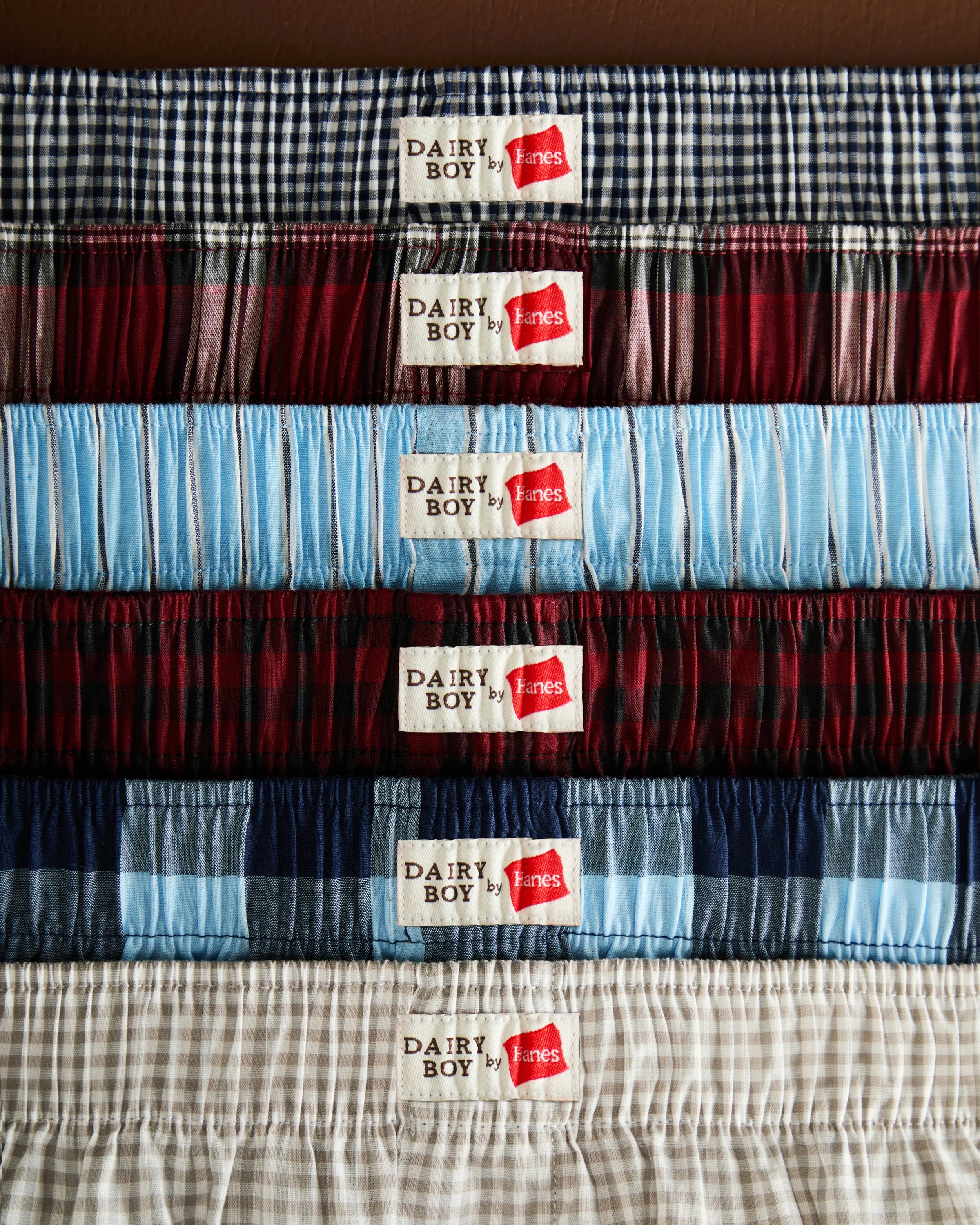 Stacked plaid boxer shorts in various patterns and colors, each with a 'Dairy Boy by Hanes' label.
