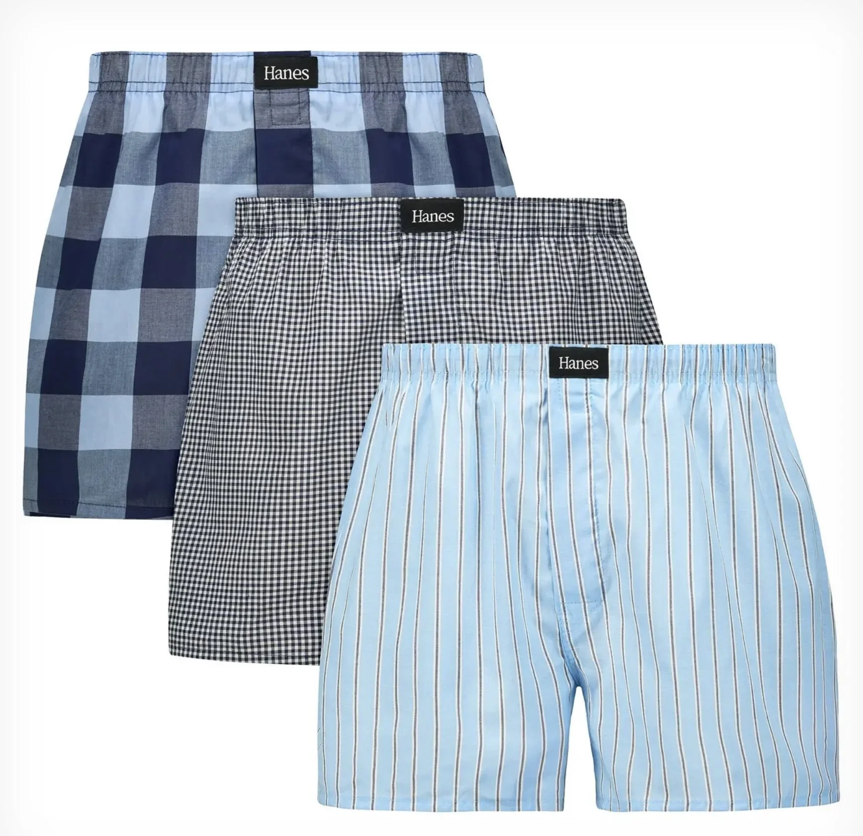 Three pairs of men's boxer shorts with different patterns, one with blue and black checks, one with black and white gingham, and one with light blue and white stripes, all with elastic waistbands and the label 'Hanes'.