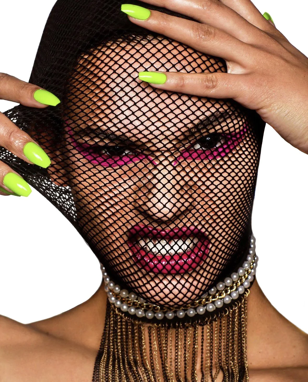 A person with bright green nails and makeup is behind a black fishnet mask, revealing a face with pink eye makeup, bright pink lipstick, and a pearl necklace.