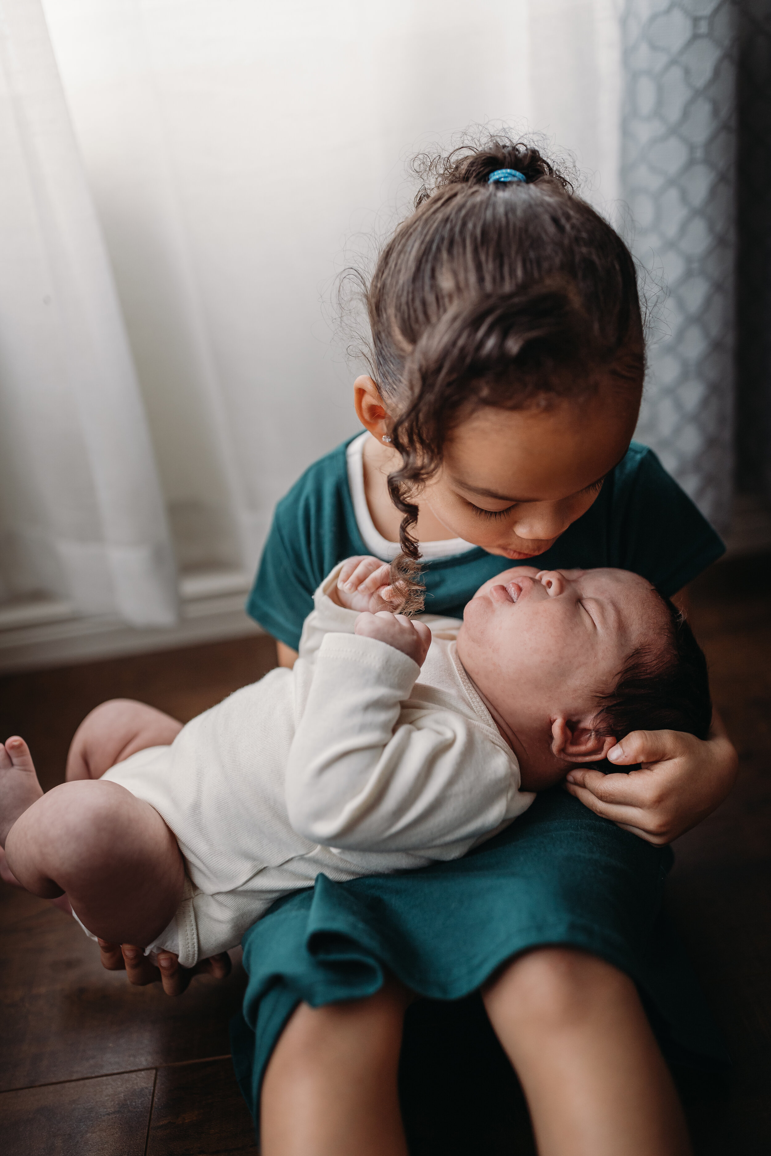 Big sister kissing brother - Lifestyle Newborn Photos in  clients Home with Baby Boy and family photo and outfit ideas