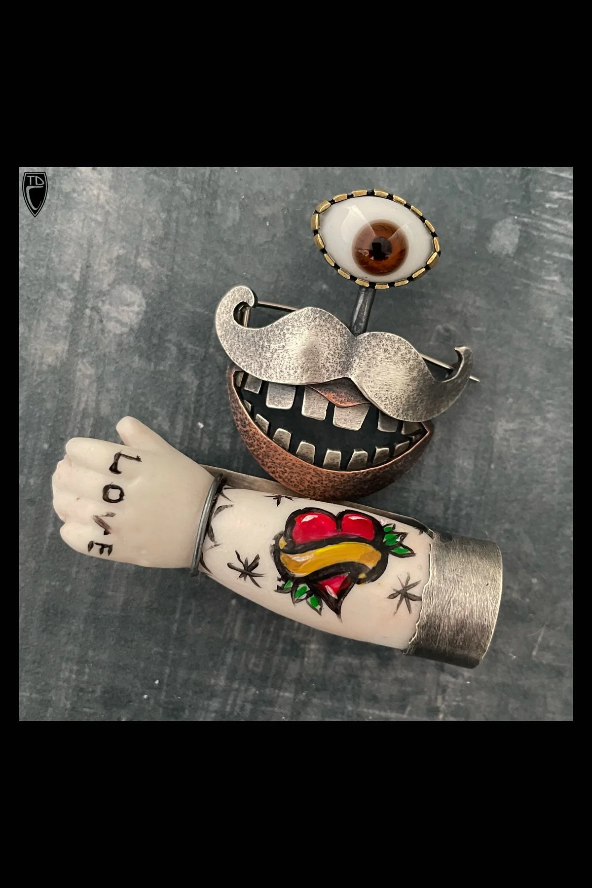 "One Eyed Earl", Sterling Silver, Copper, Brass, Antique Glass Doll's Eye, Antique Porcelain Doll's Arm, and Paint Brooch/Pendant
