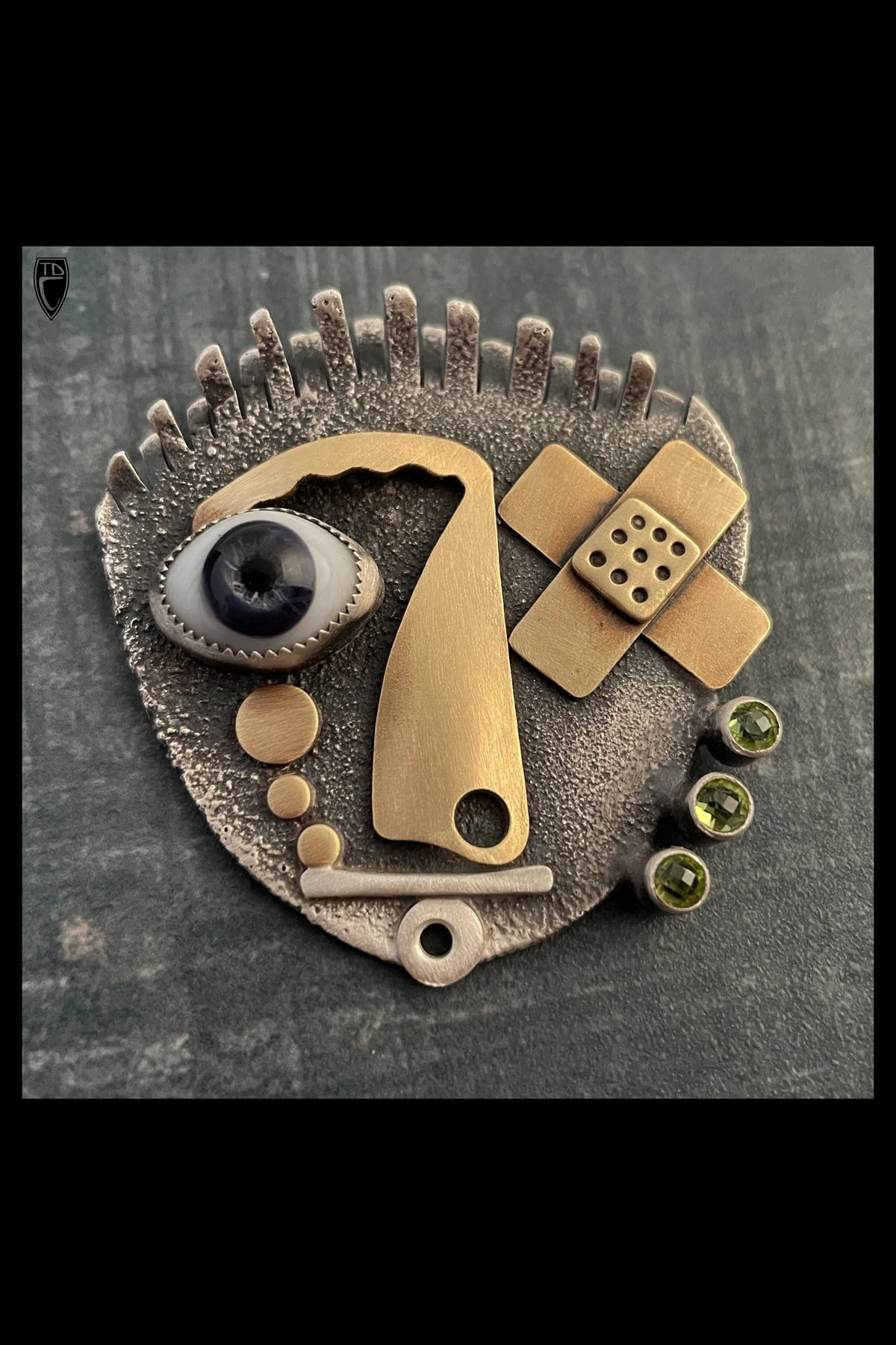 "Eyerony" They say what doesn’t kill you makes you stronger, Sterling Silver, Brass, Vintage Glass Doll's Eye, Peridot and Steel Brooch