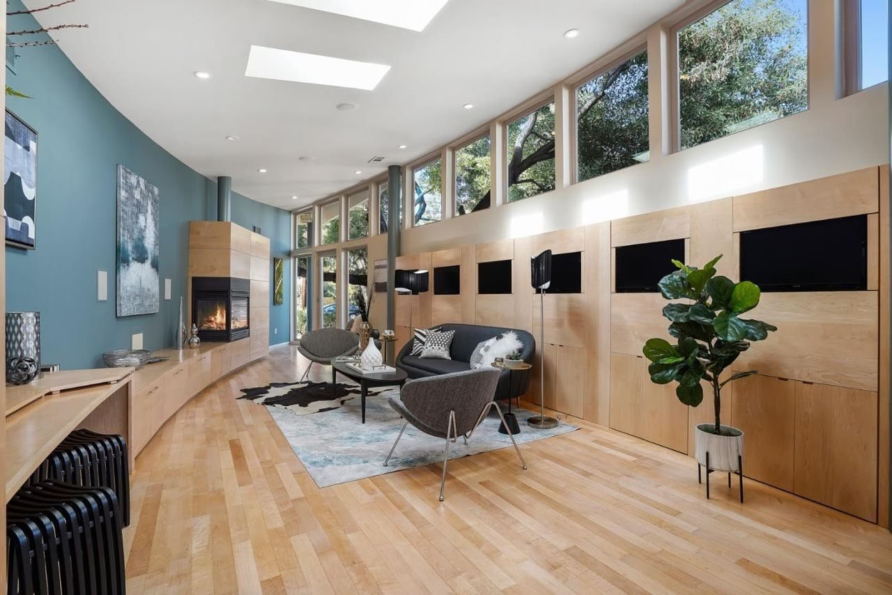 Staged great room with a fireplace and the built-in monitor wall at 475 Fernando Avenue in Palo Alto
