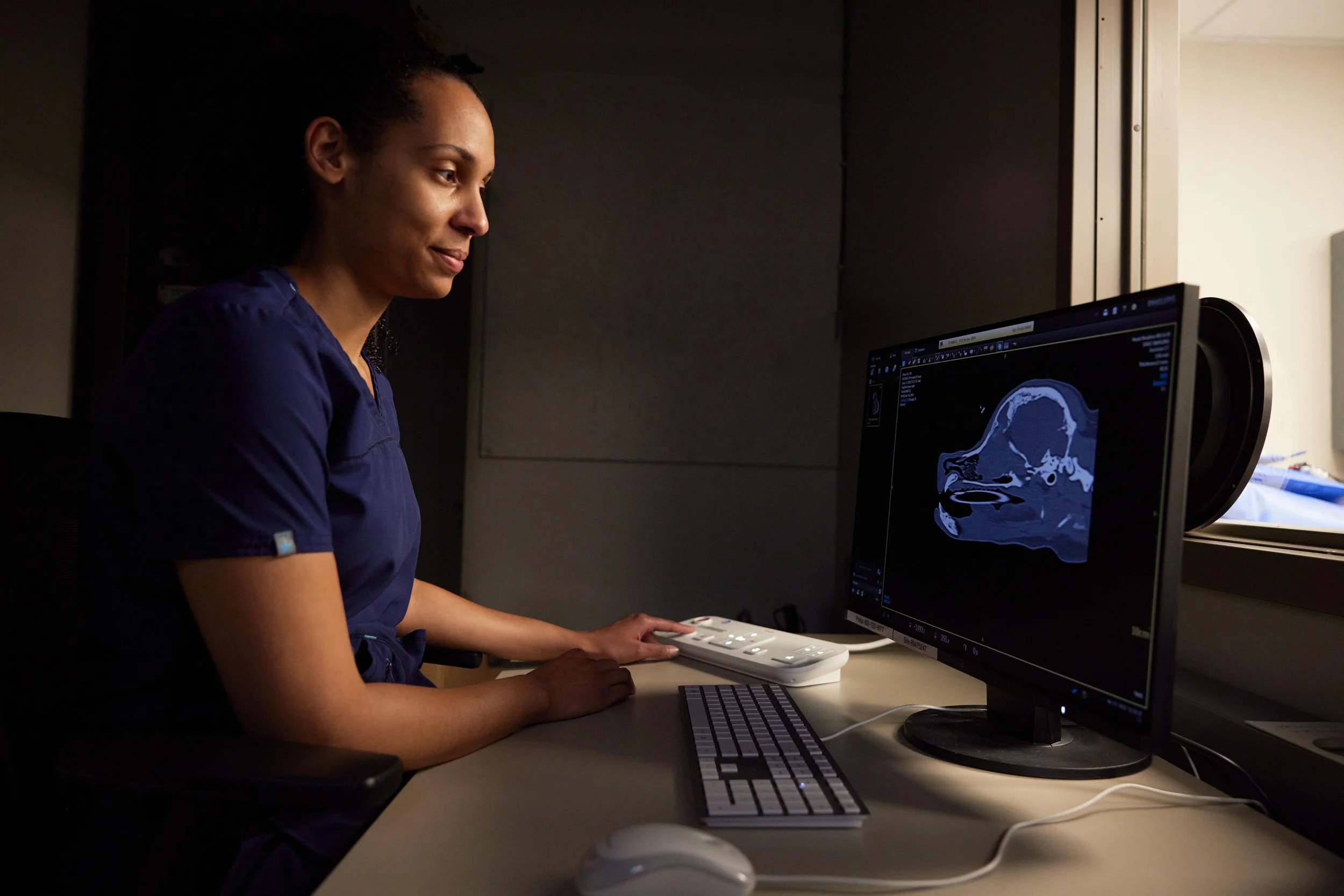 A board-certified veterinary radiologist reviews a CT scan as part of same-day diagnostic reporting. Photo by Kevin Vargo for Sage Veterinary Imaging