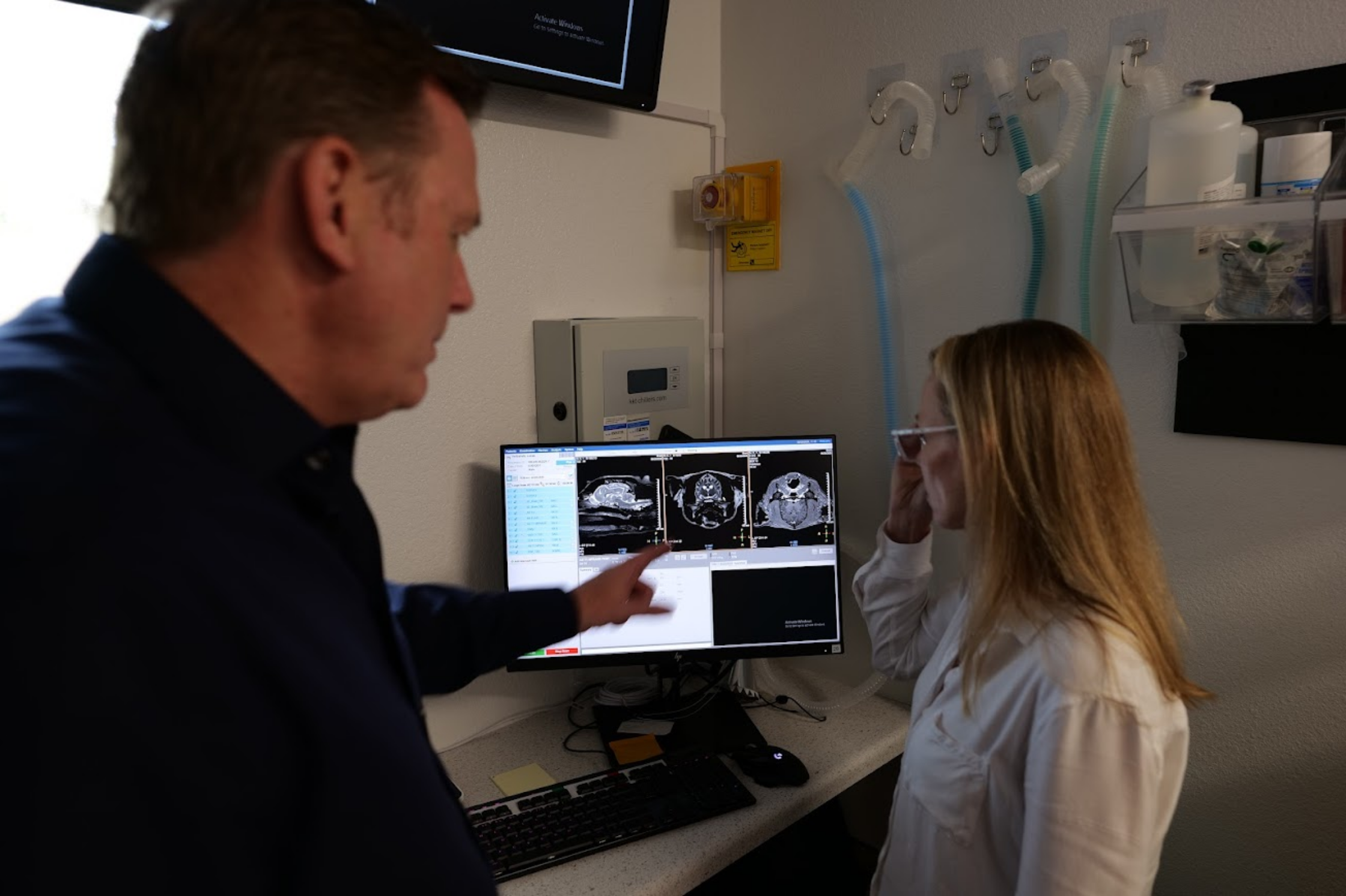 Veterinary specialists reviewing MRI images on a diagnostic workstation