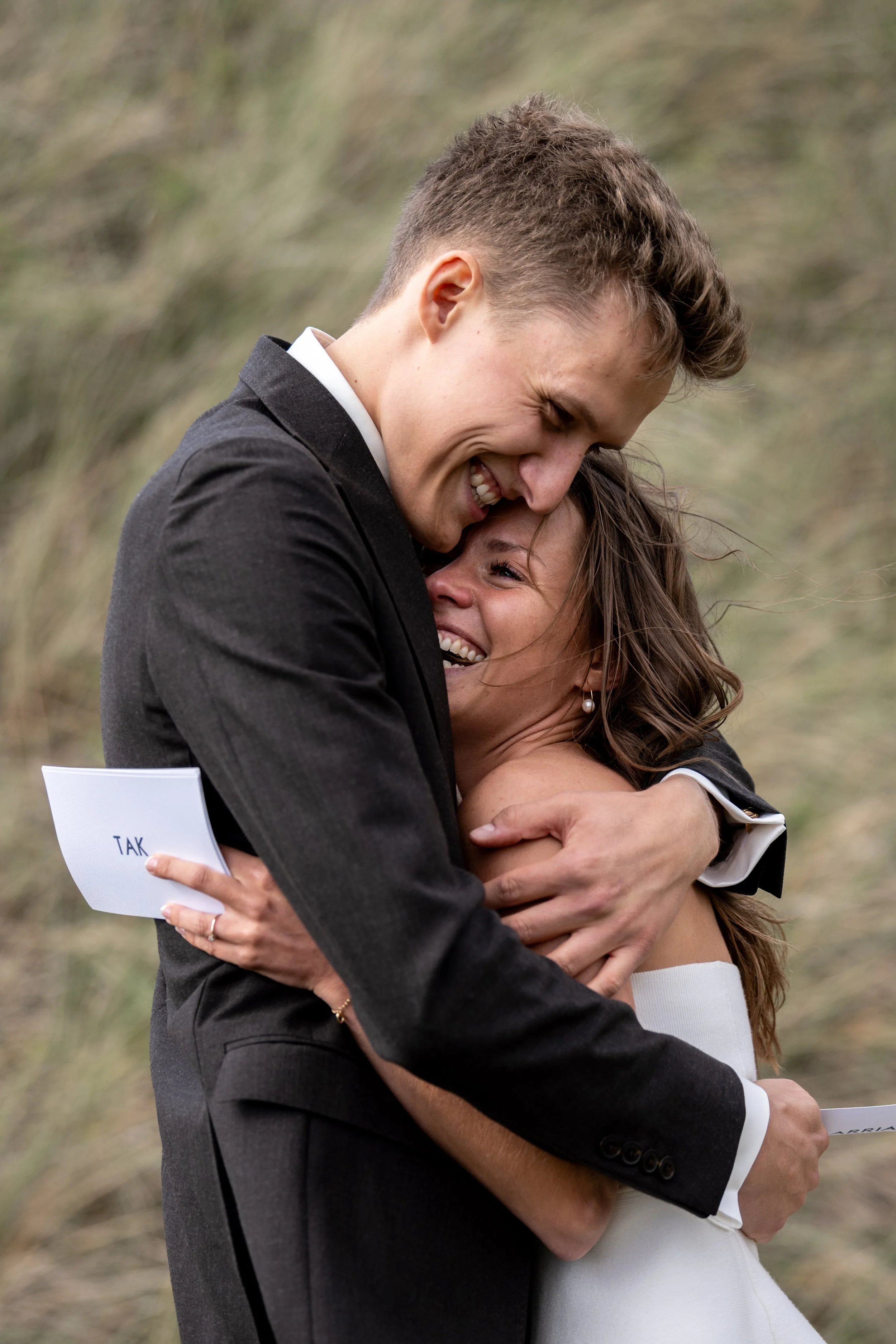 A couple hugging after reading their vows for each other at their elopement with North Sea Elopements on the west coast of Denmark