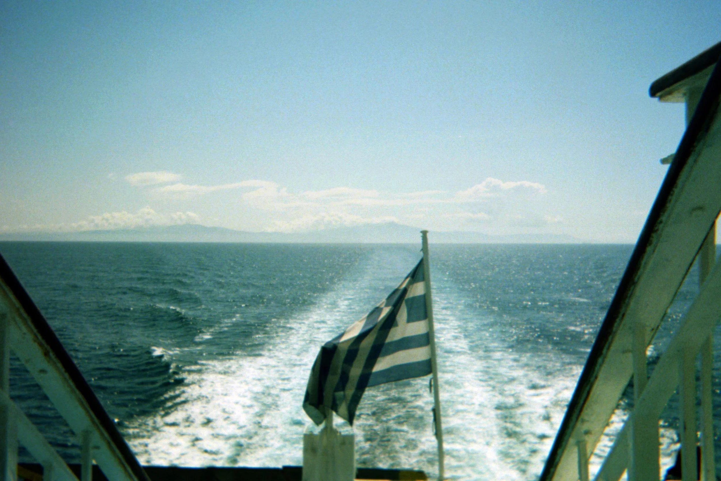 Greek flag on a ferry with ocean waves behind