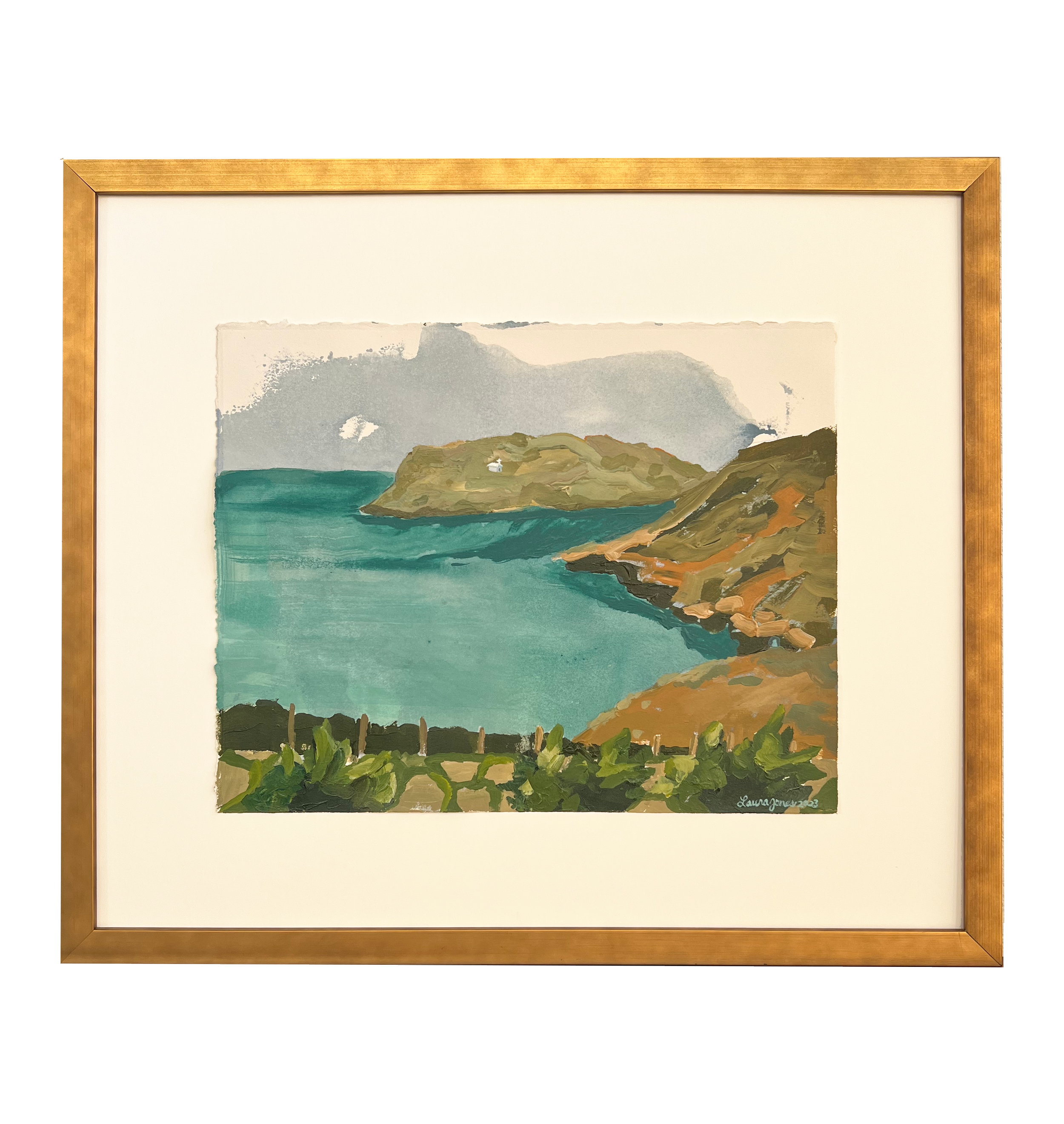 Framed painting of a coastal landscape with green hills and blue sea.