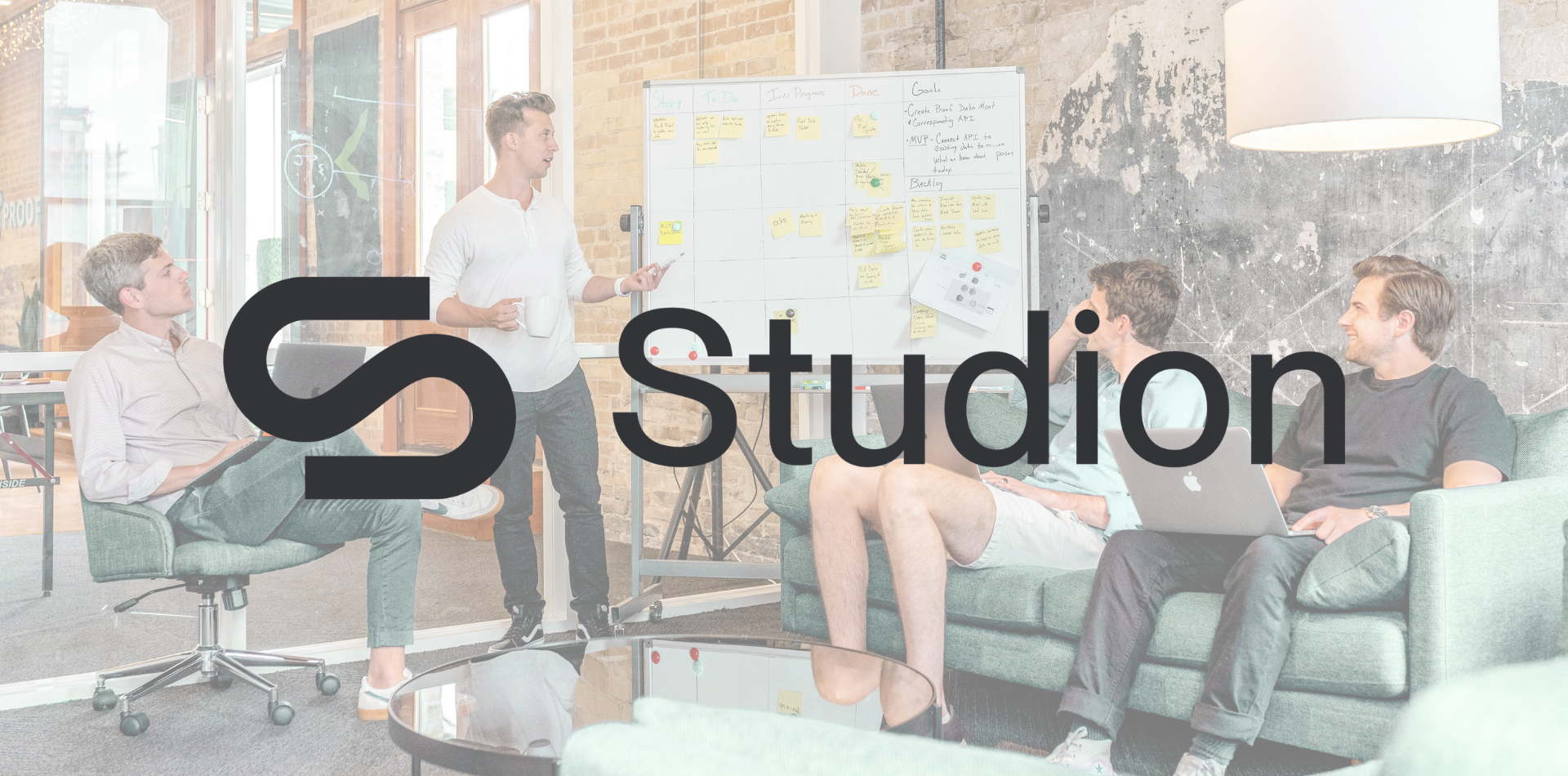 Image of team working together with Studion Logo in the front