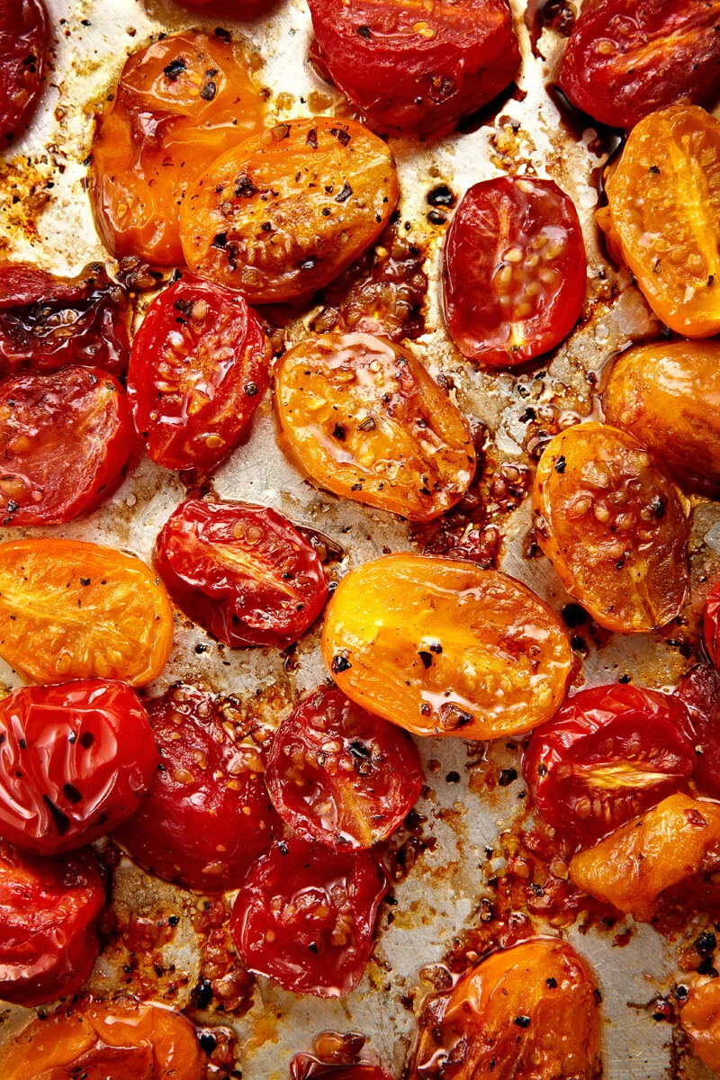 Cherry tomatoes roasted in the oven shot overhead as part of an editorial series based on recipes.