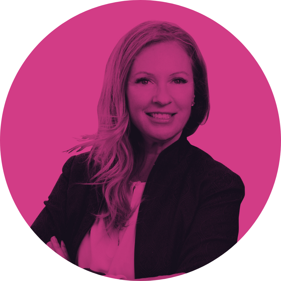 A woman with long hair smiling, wearing a black jacket and white top, against a pink background.