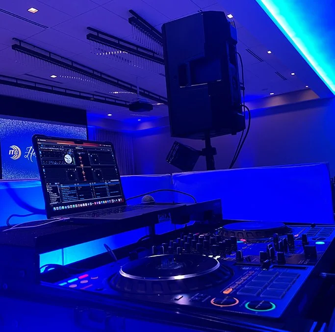 Professional DJ equipment setup with blue LED uplighting.