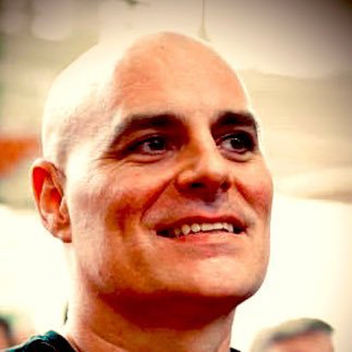 A clean, close-up portrait of Sr. Content Strategist, Charles Dye, featuring a confident, approachable smile in an indoor backdrop at Nike's Bo Jackson gym.