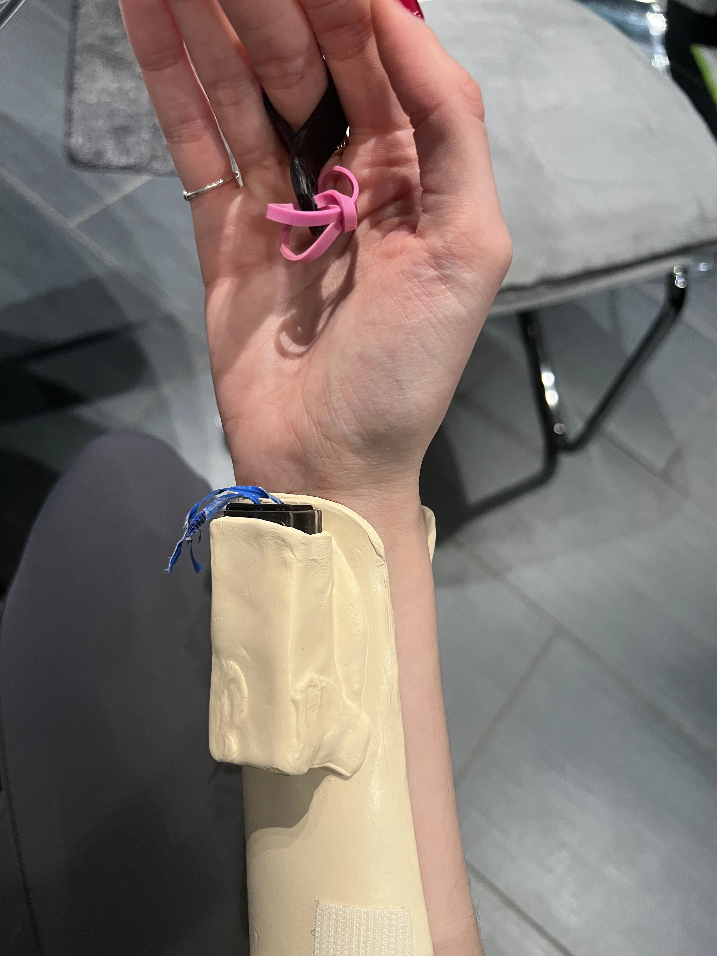 Adjusting the pulley mechanism with proper line of pull so it won’t trigger accidentally, and will trigger with wrist extension + chosen finger extension( a motion less likely to happen naturally, so compartment doesn't pop open from regular hand mot