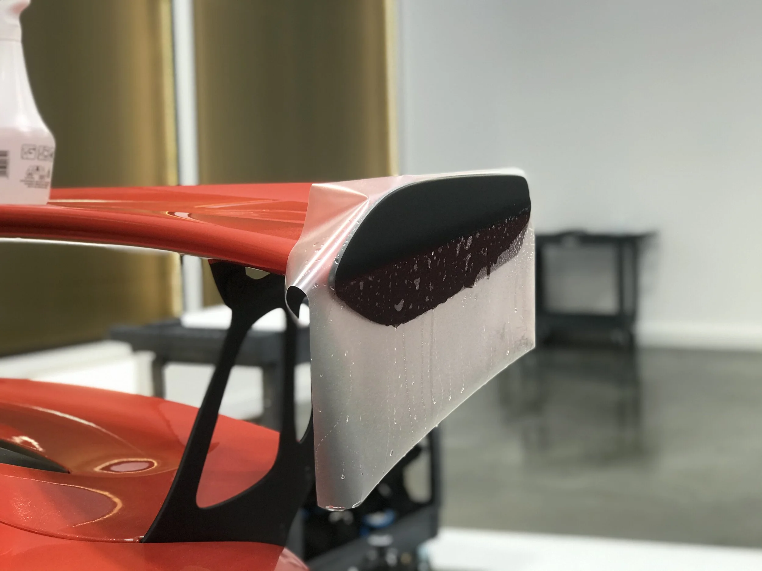 Student practising vinyl wrapping techniques at The Auto Sanctuary training academy