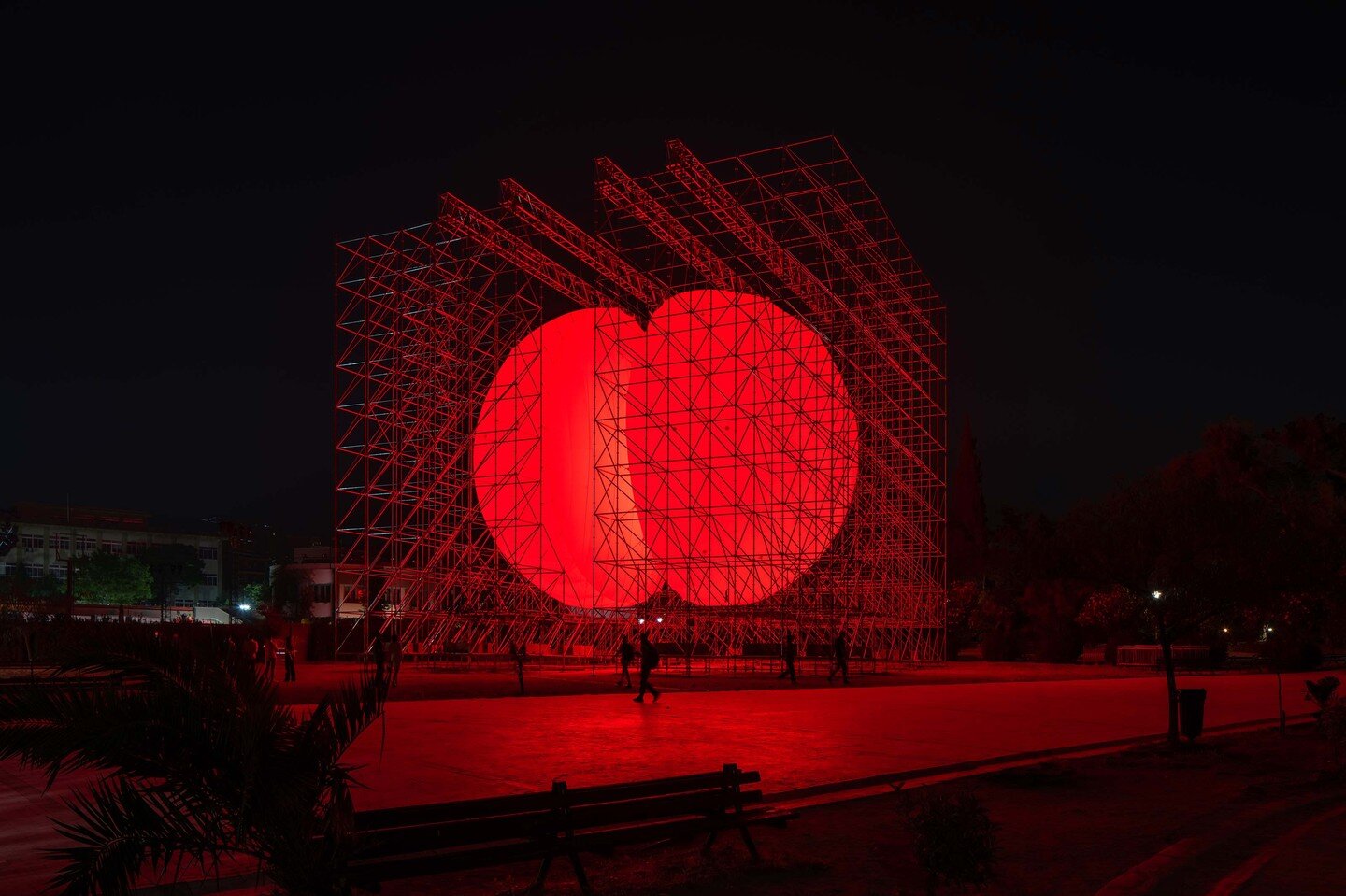 DIVIDED
Athens - Greece, 2022

A huge, luminous sphere of an intense red color, split in two identical halves. Each half is caged within a metal structure built with the kind of scaffolding commonly used in construction.

Viewers can traverse the spa