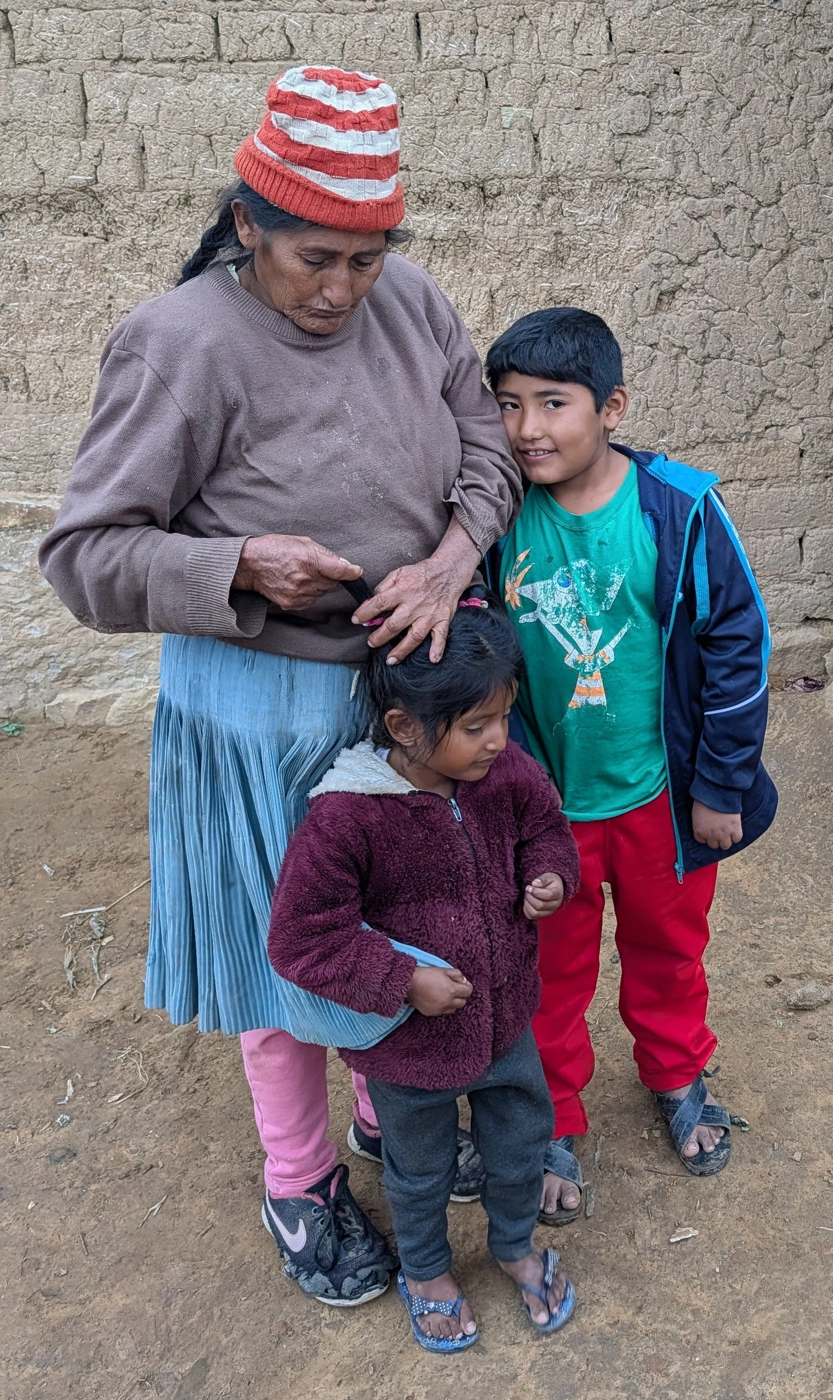 A mother and two children outside their home in San Julián Bajo