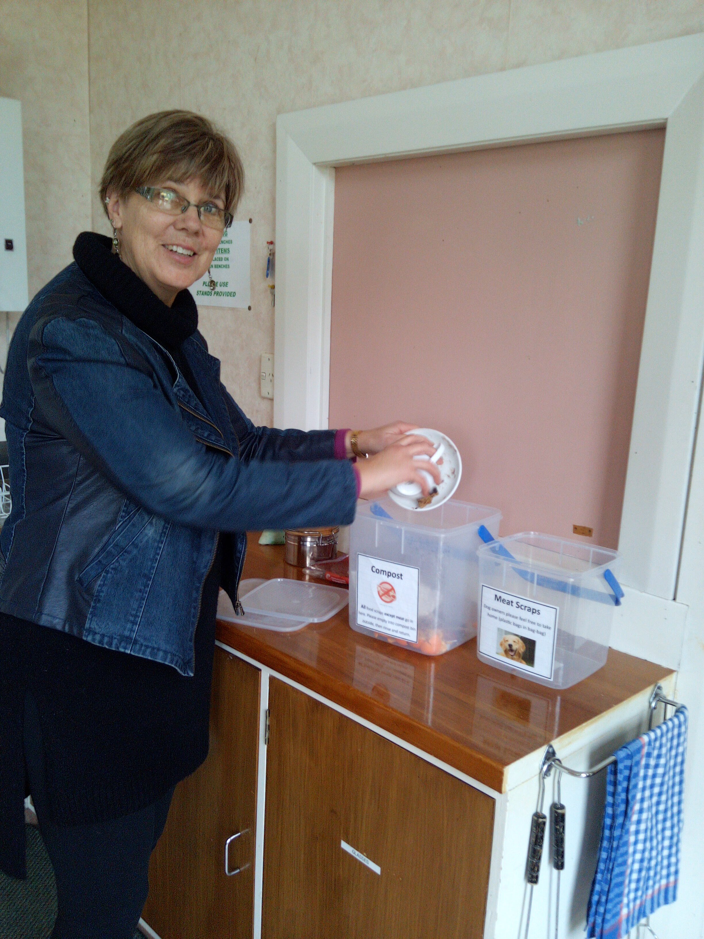 Liz Toki demonstrating how to separate food scraps in the church kitchen.