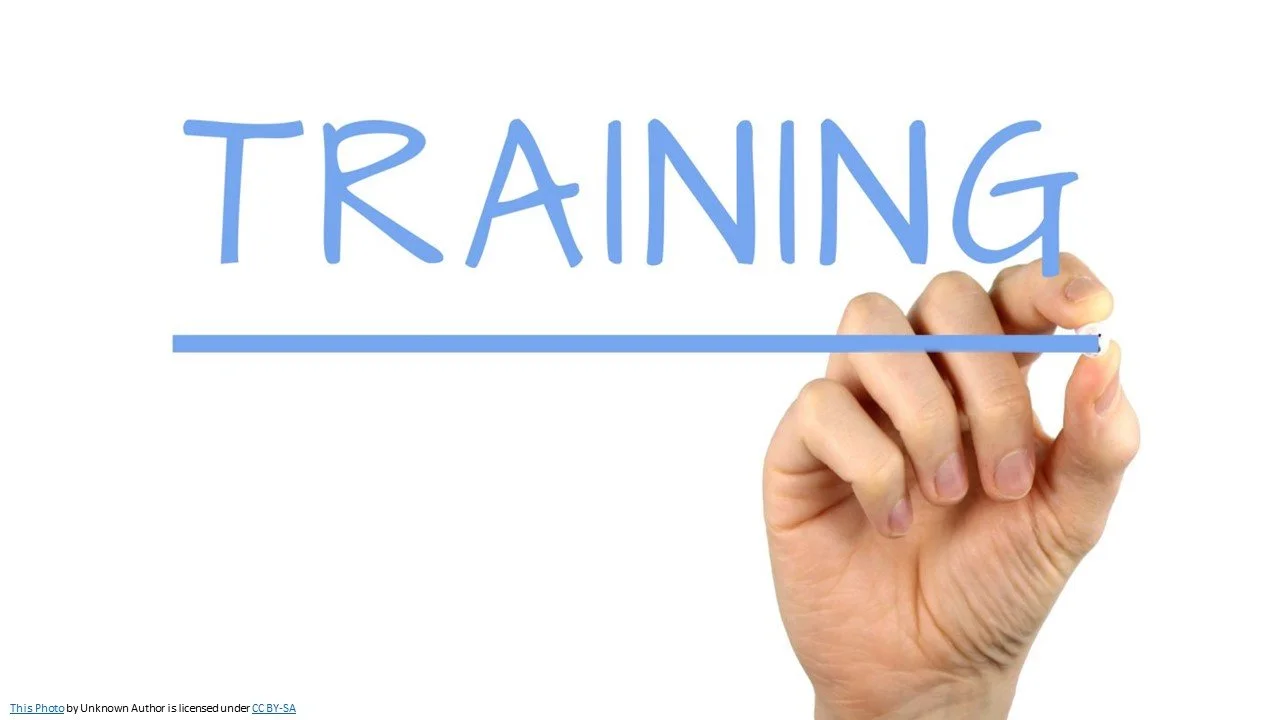 A hand writing the word training