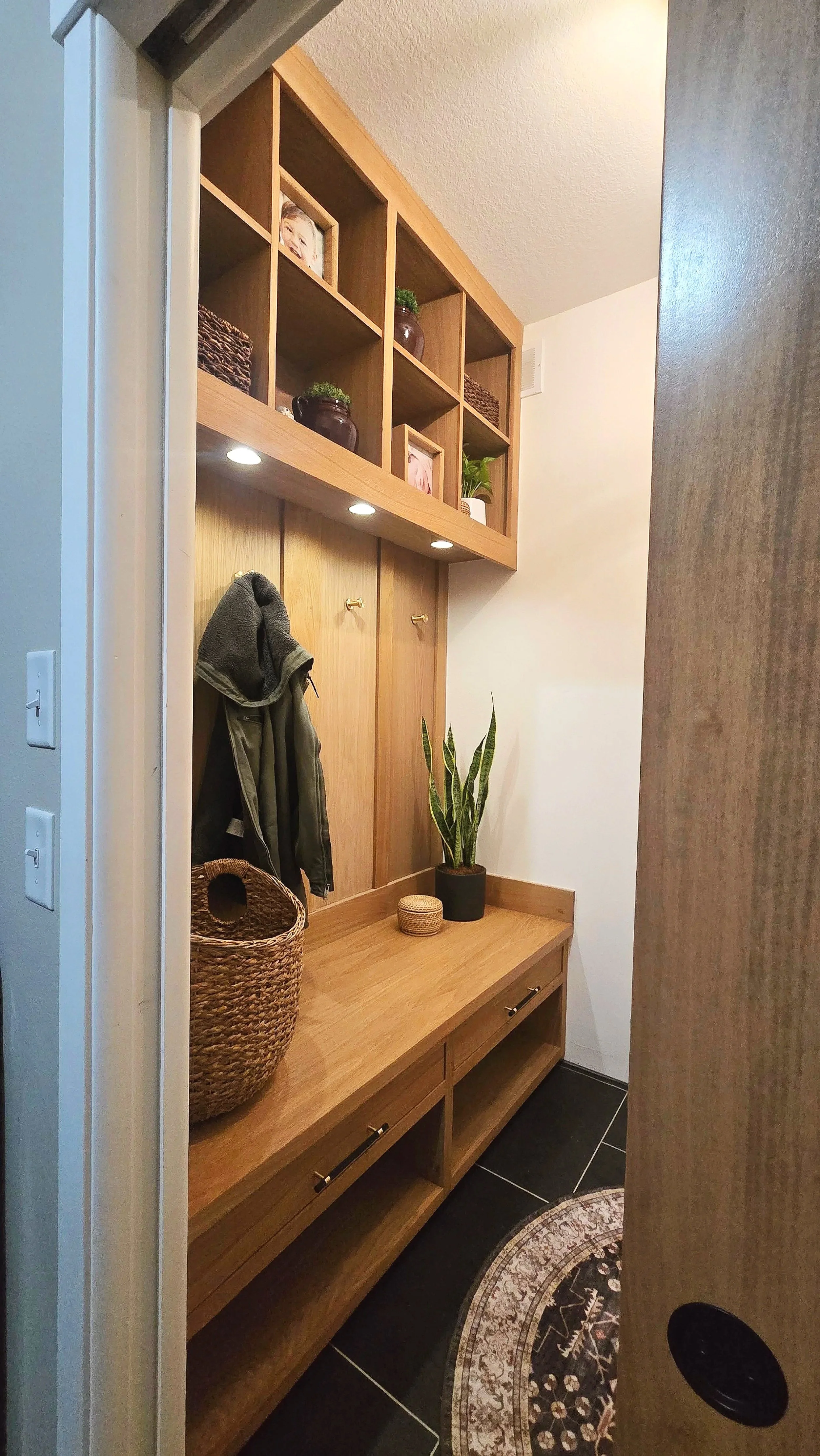 Empty black shelving unit with three sections and drawers at the bottom in an indoor space.