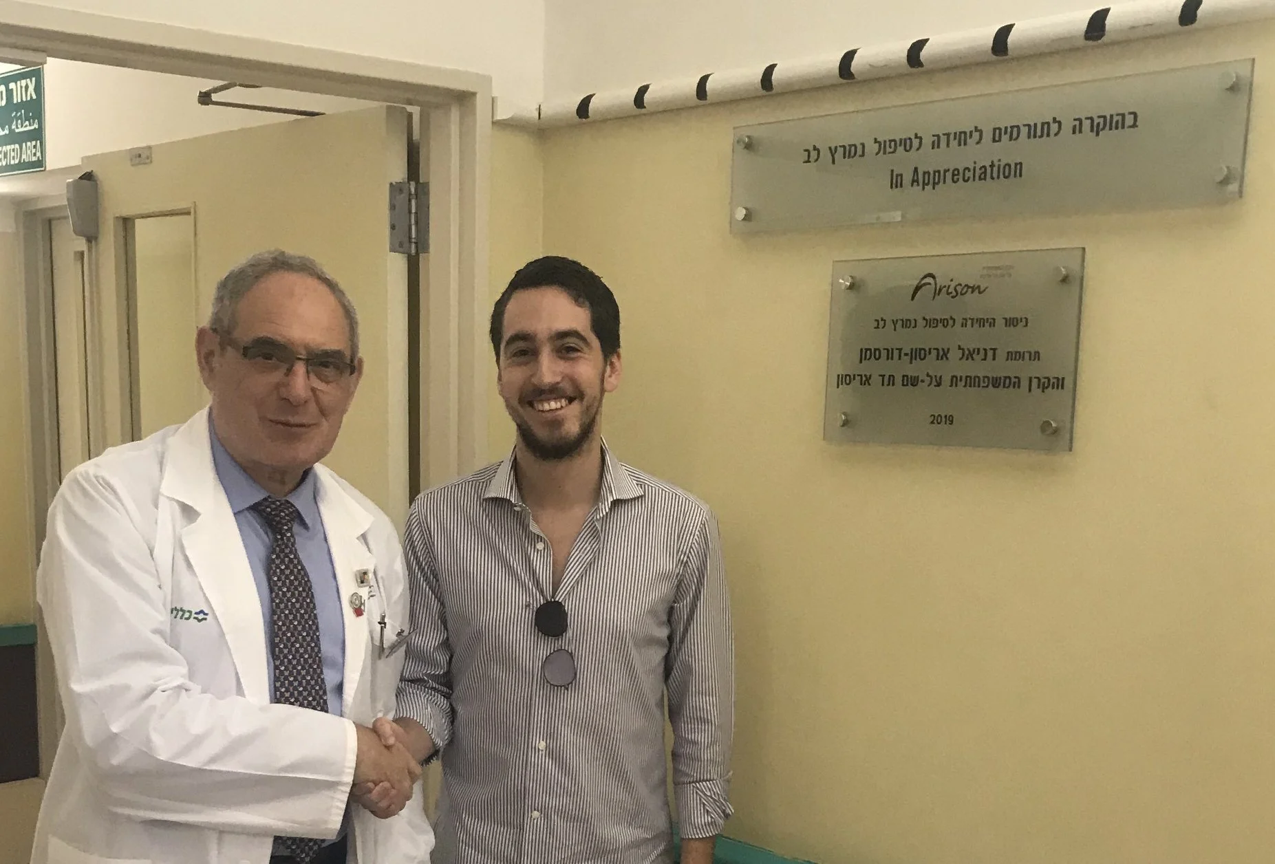 דניאל אריסון דורסמן ופרופ' יוסף פרס ליד שלט ההנצחה