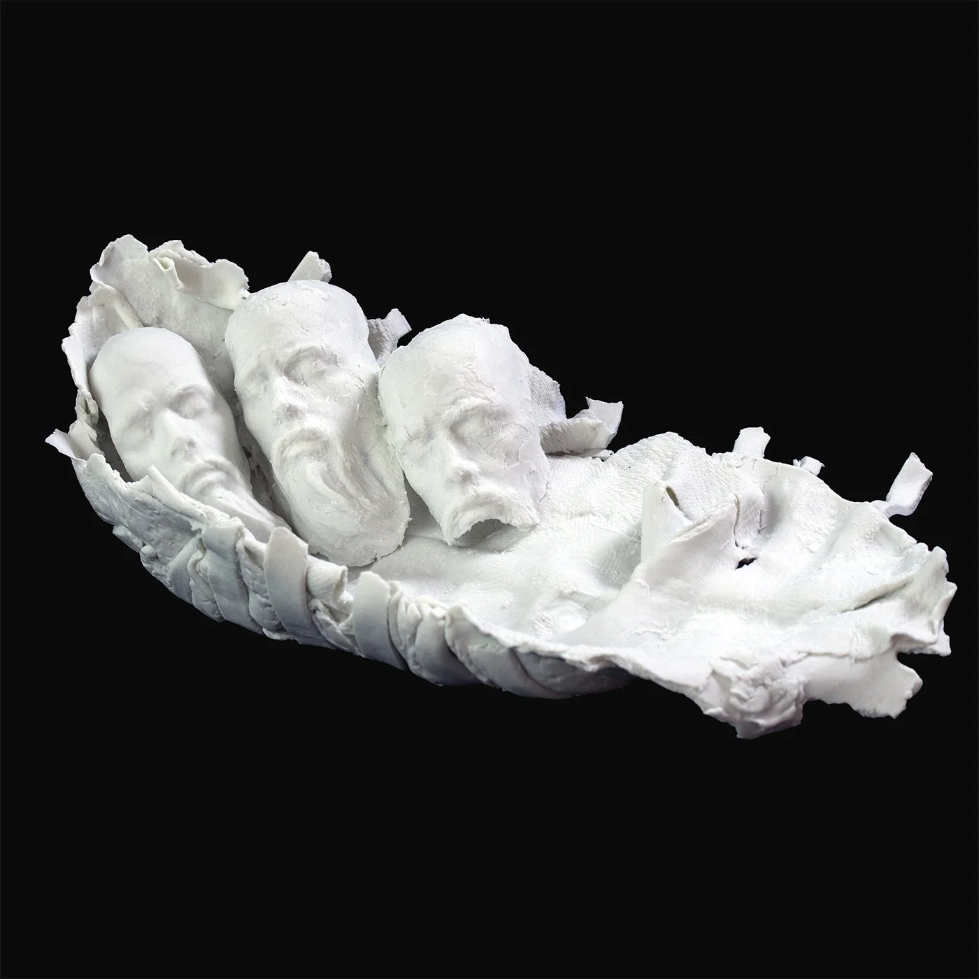 bisque porcelain sculpture with three sculpted heads resting in a crumpled porcelain tray form on black background