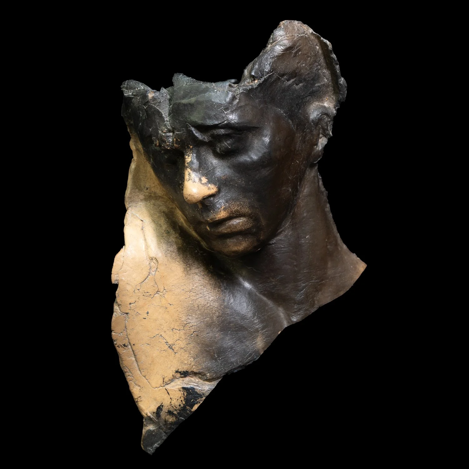 Dark ceramic fragment of a male head and torso against a black background.