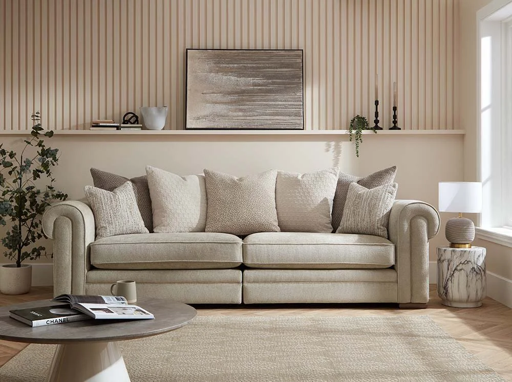 Living room with beige sofa, multiple cushions, marble side table, table lamp, plants, and wall décor in neutral tones.