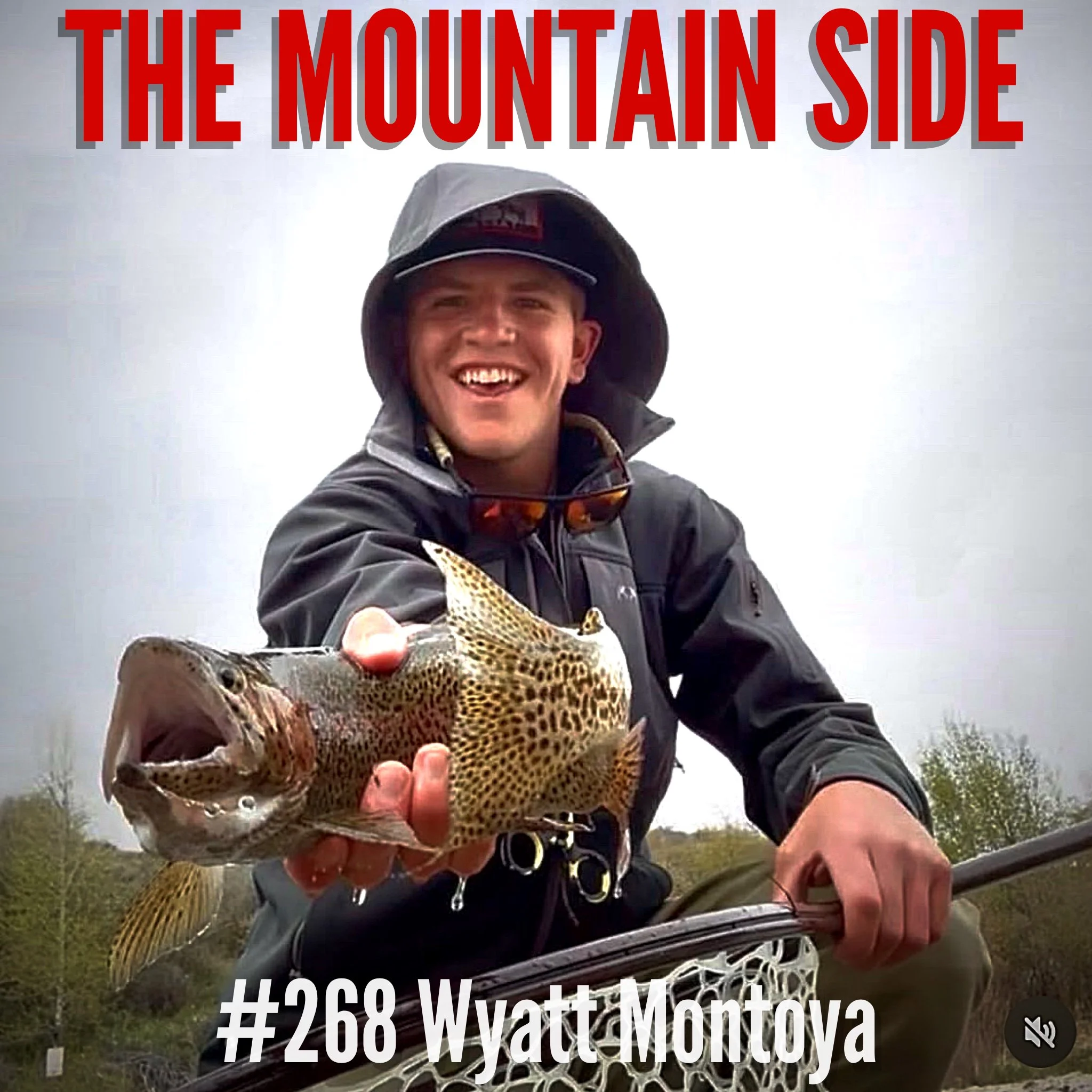 A person smiling while holding a fish, with text overlay reading 'The Mountain Side' and hashtag '#268 Wyatton Montana'. The person is wearing outdoor gear and a hat, and the background appears to be outdoors with trees and a cloudy sky.