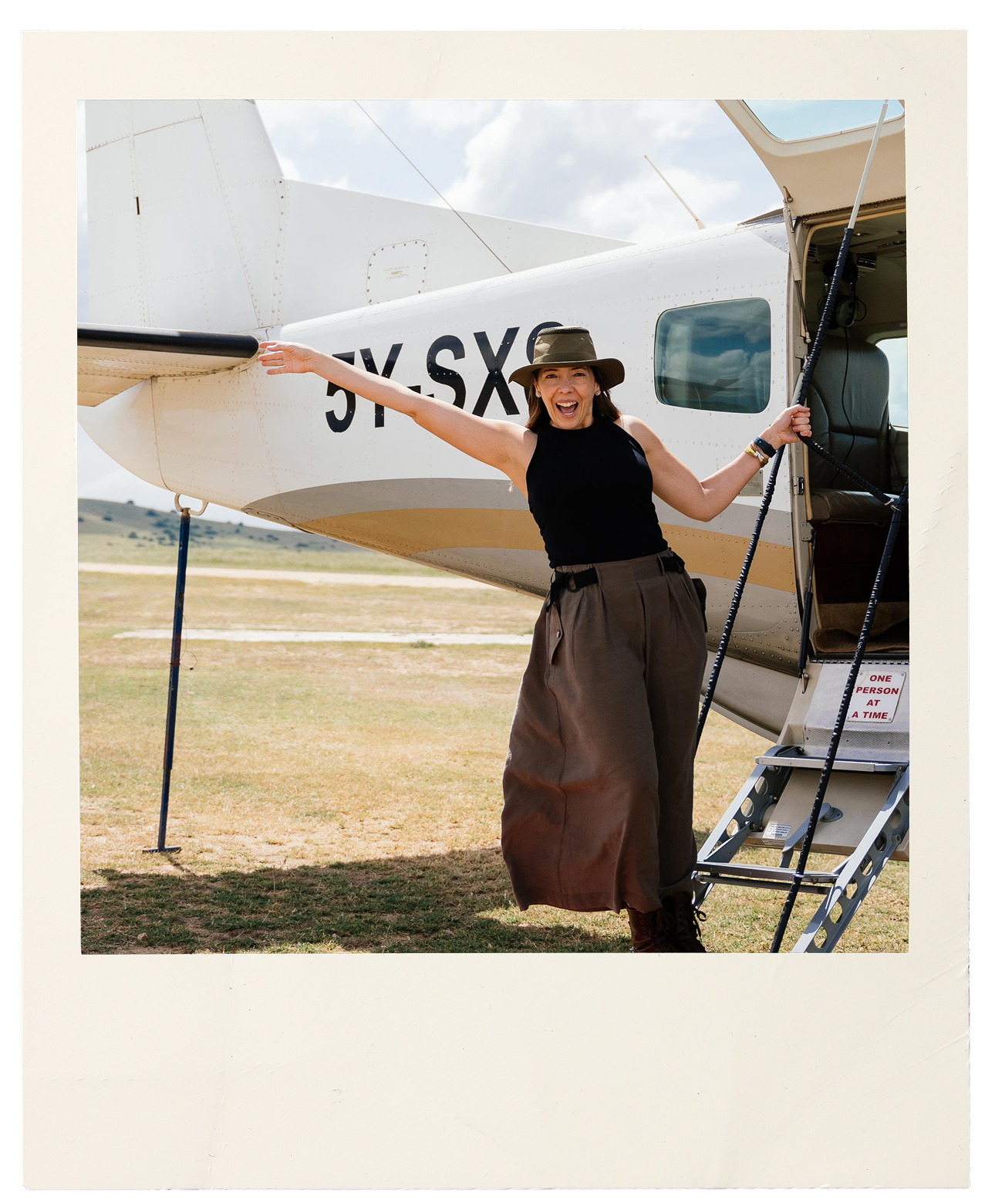 Virgi Schiffino, Managing Partner at Lux Voyage, standing in front of a small aircraft on an African airstrip