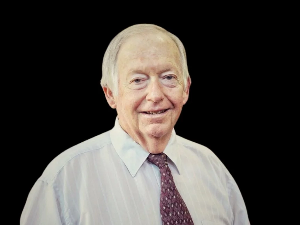 Elderly man in white shirt and patterned tie on a black background