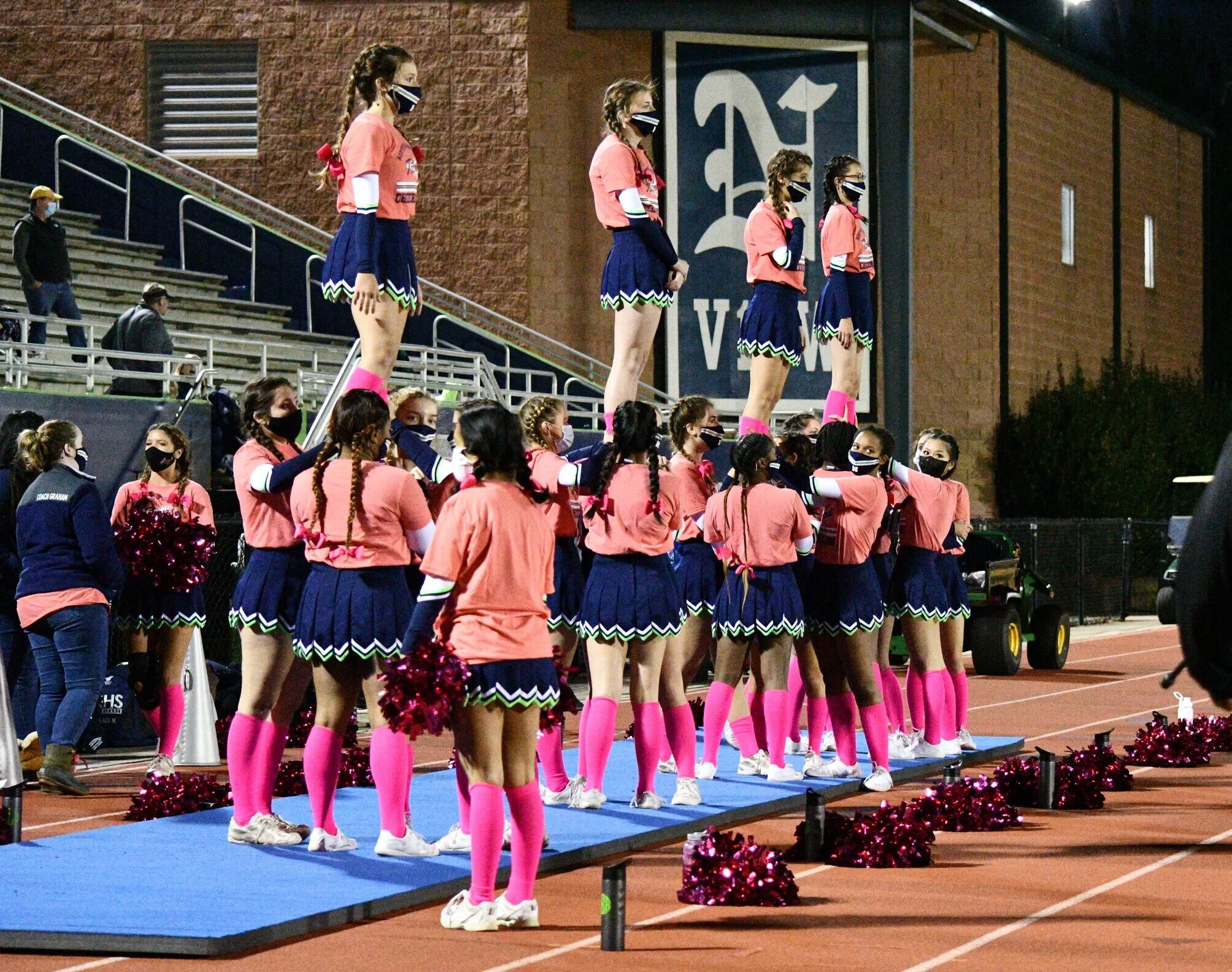 Northview's sideline cheer team shows off stunts while decked out in pink.