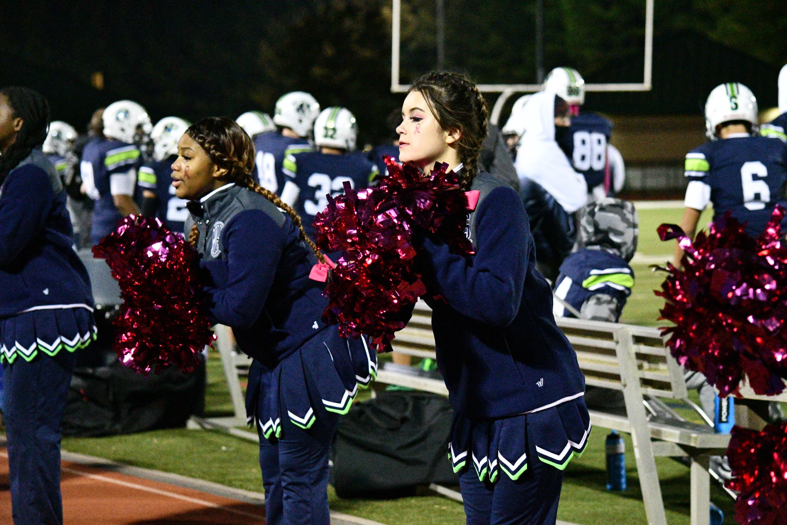 Sophomore Amber Holda cheers with pompoms for their sideline routine.