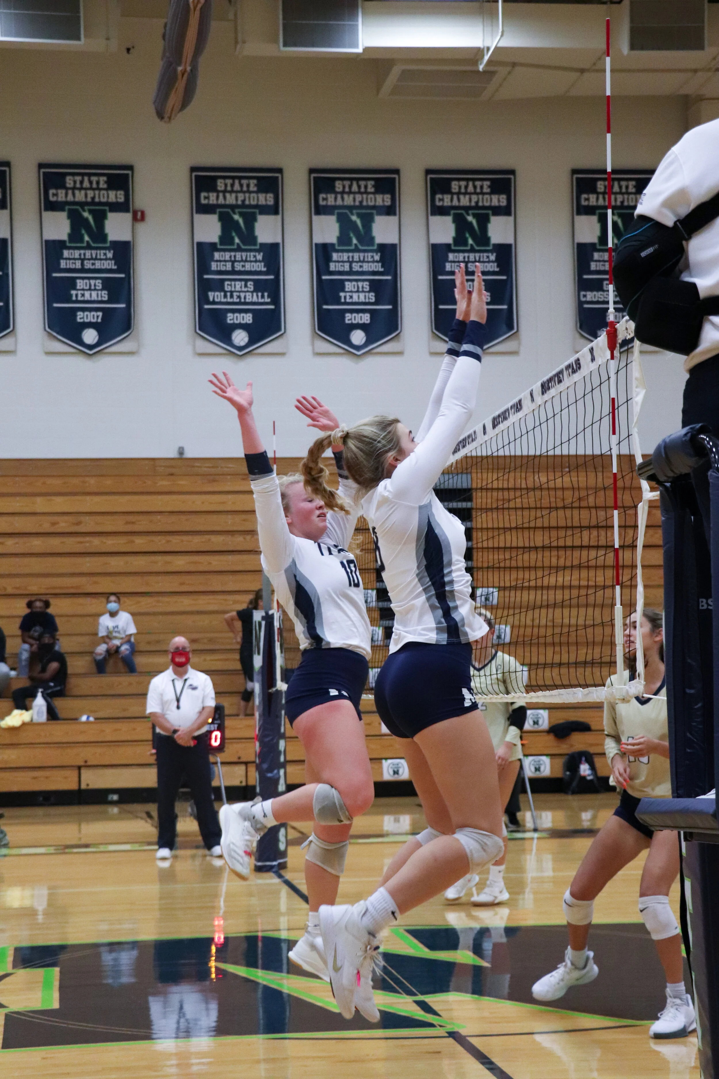 Seniors Kate Holland (right) and Emma Wisham (left) attempt a block against the opposing team's hit.