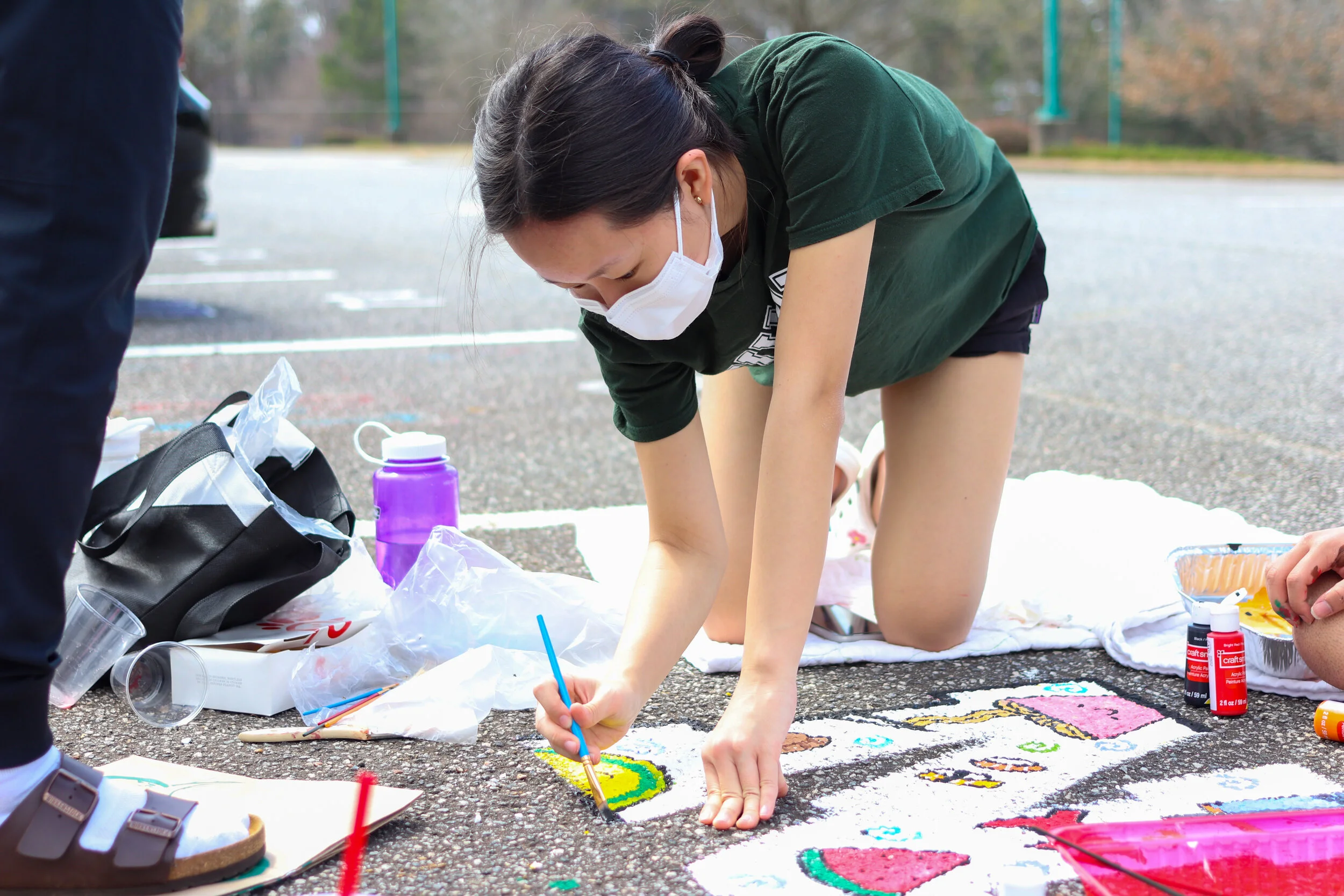 Senior Kristin Hsu paints her parking space in the senior parking lot.