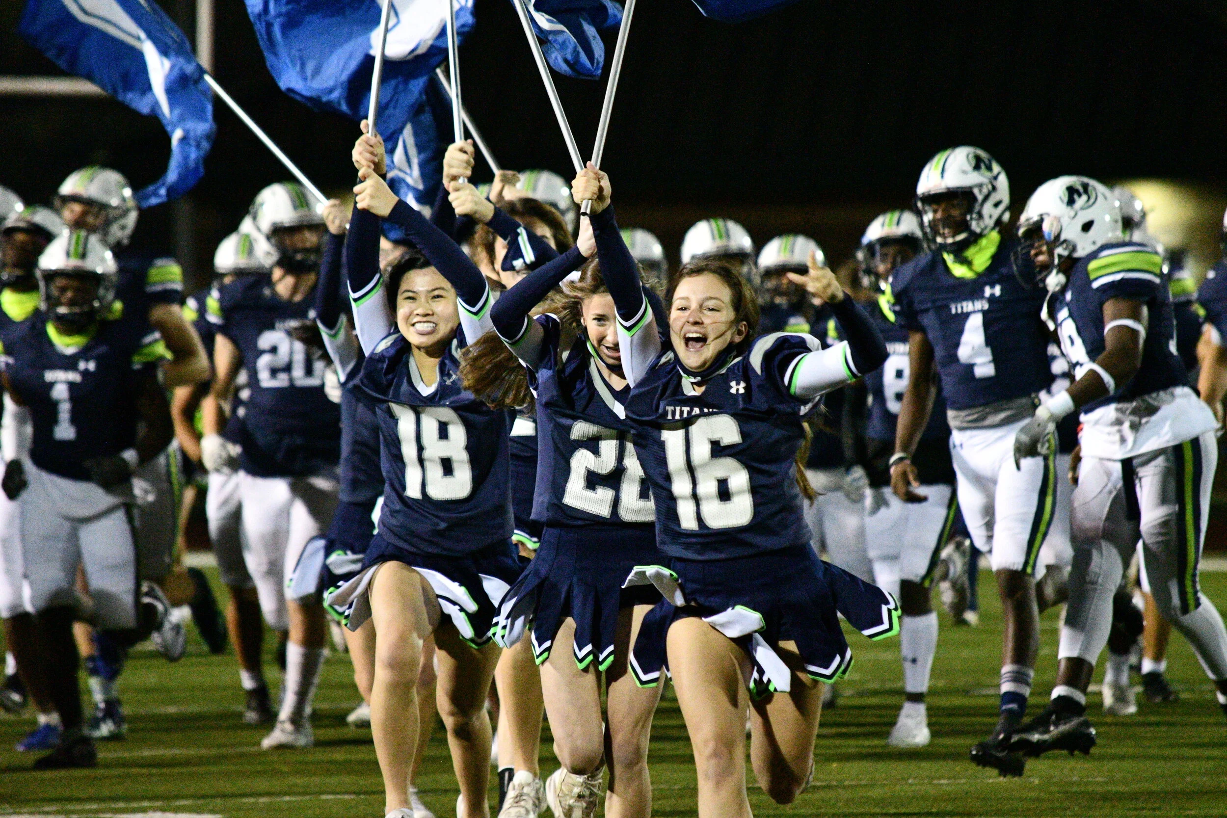 Sophomore Alisa Adkins leads the charge during Friday night football, waving the Titan flag across the field.