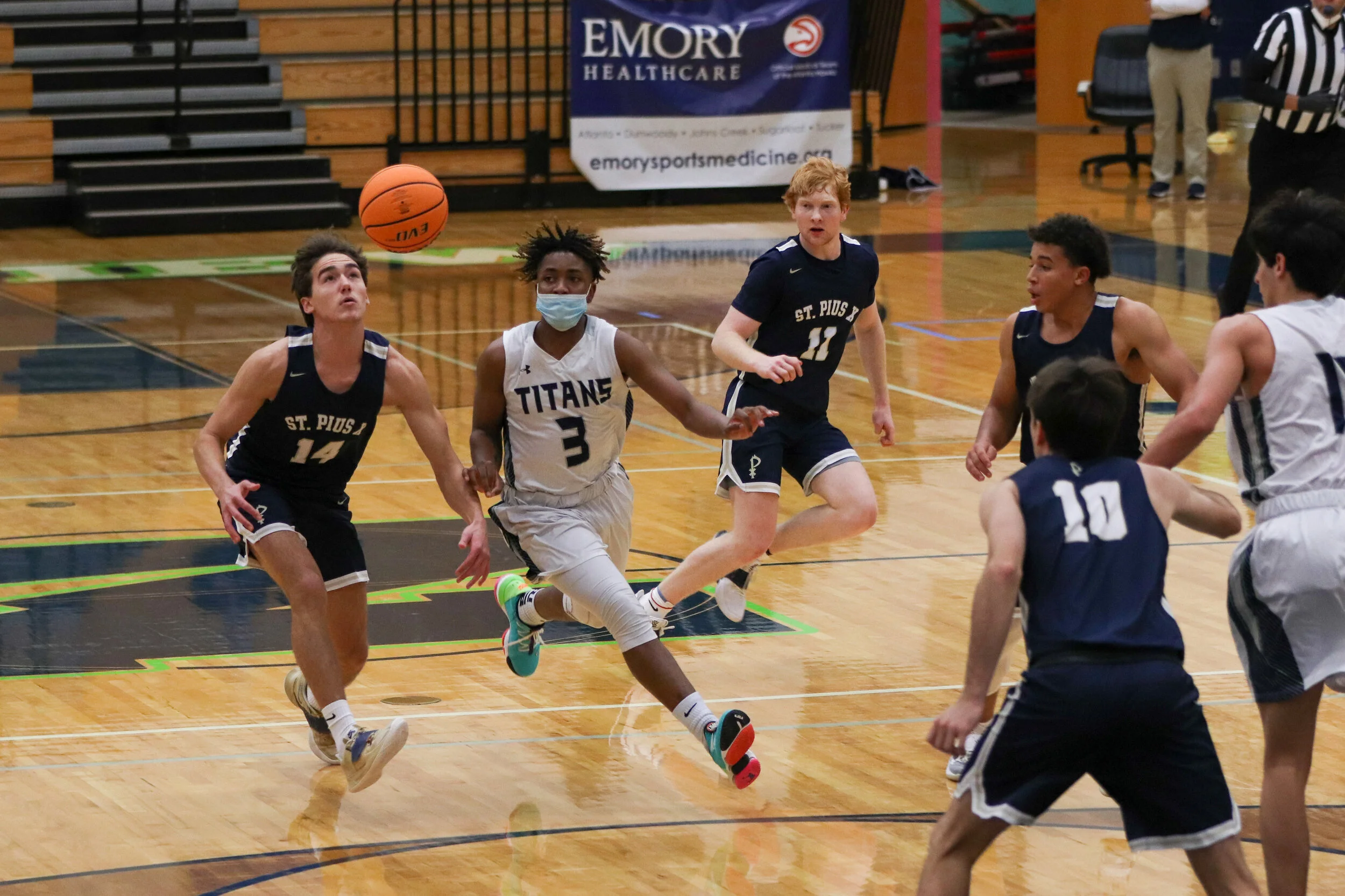 Senior Keshawn Williams travels across the court, hoping to steal the ball away from his St. Pius X High School opponent.